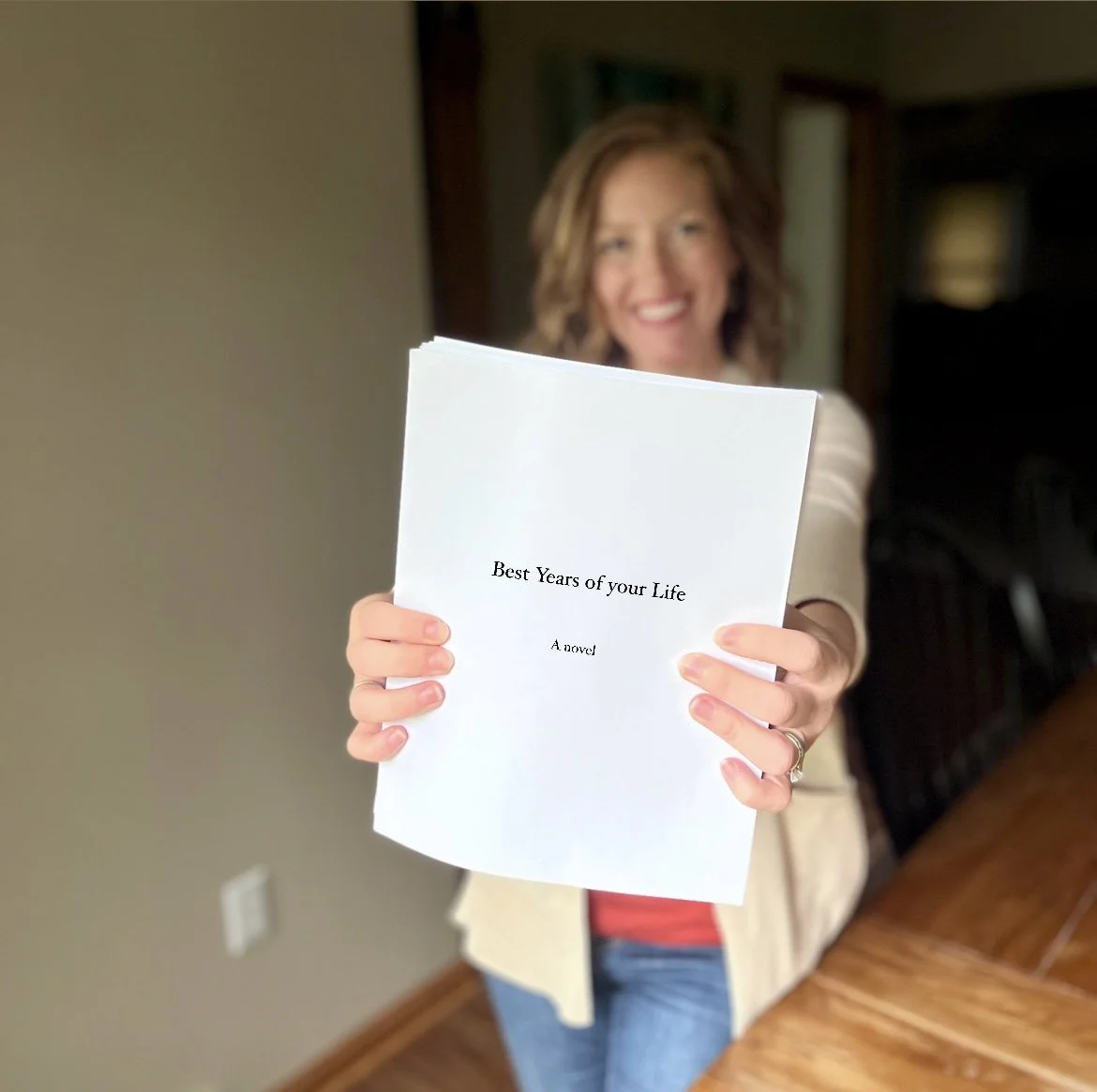 Author Jen Craven holding her manuscript pages for her novel, Best Years of Your Life