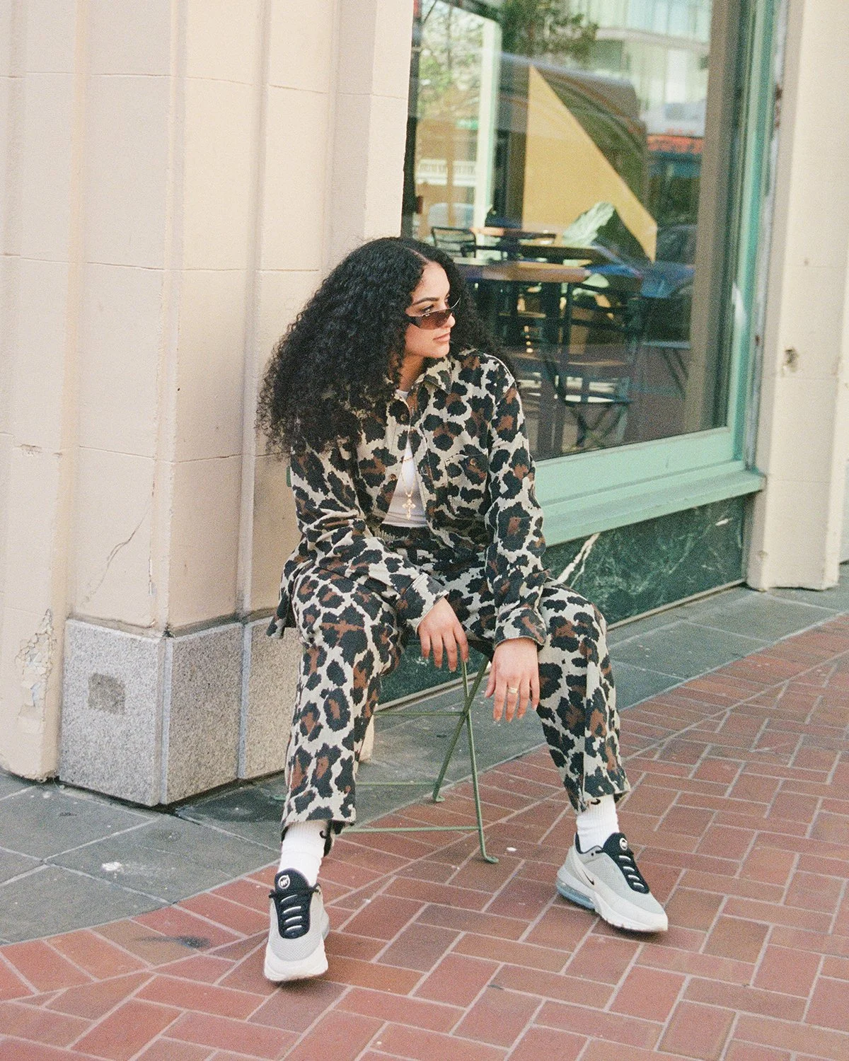 Woman sitting on side of street wearing Nike Air Max