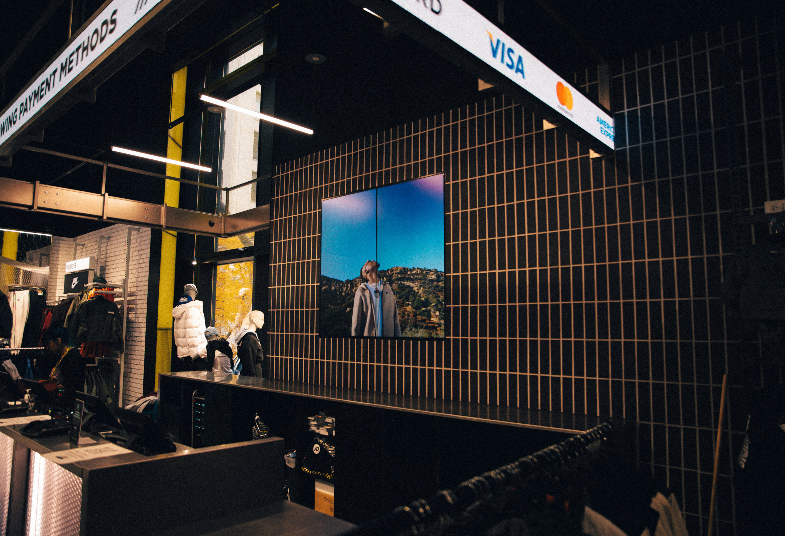 Digital screen behind JD Sports kiosk desk