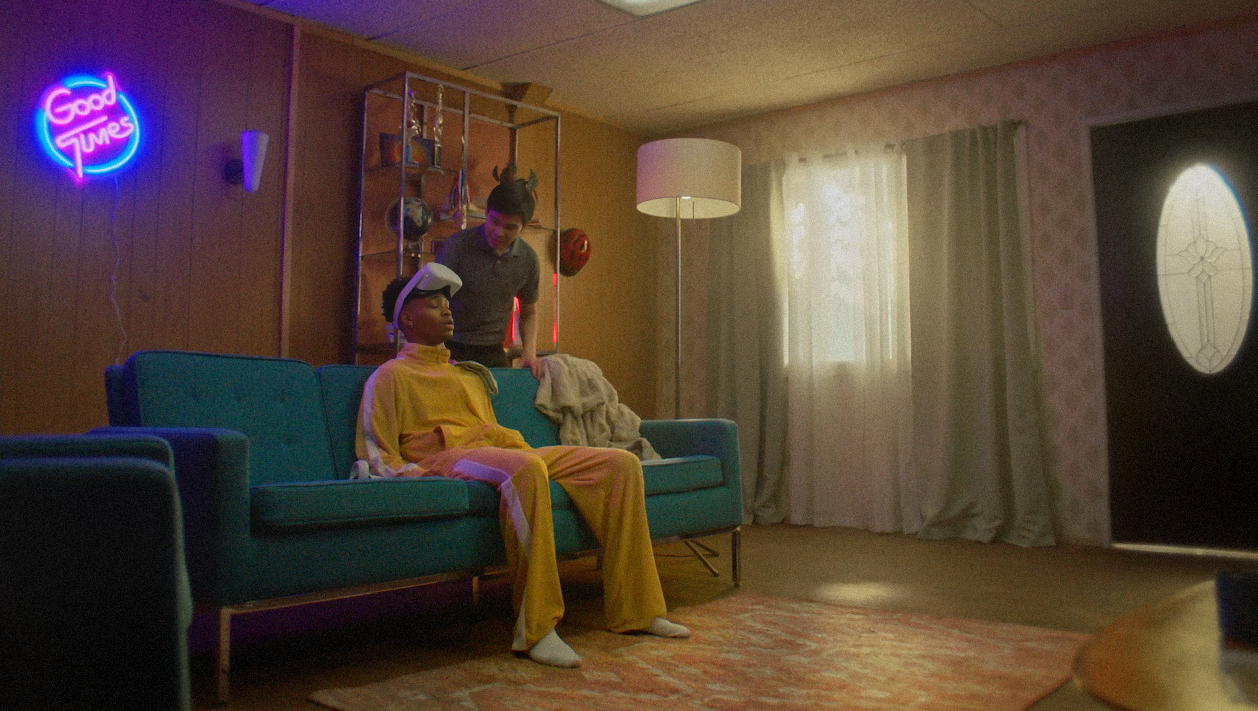 Guy in a yellow track suit sitting on couch with VR head set