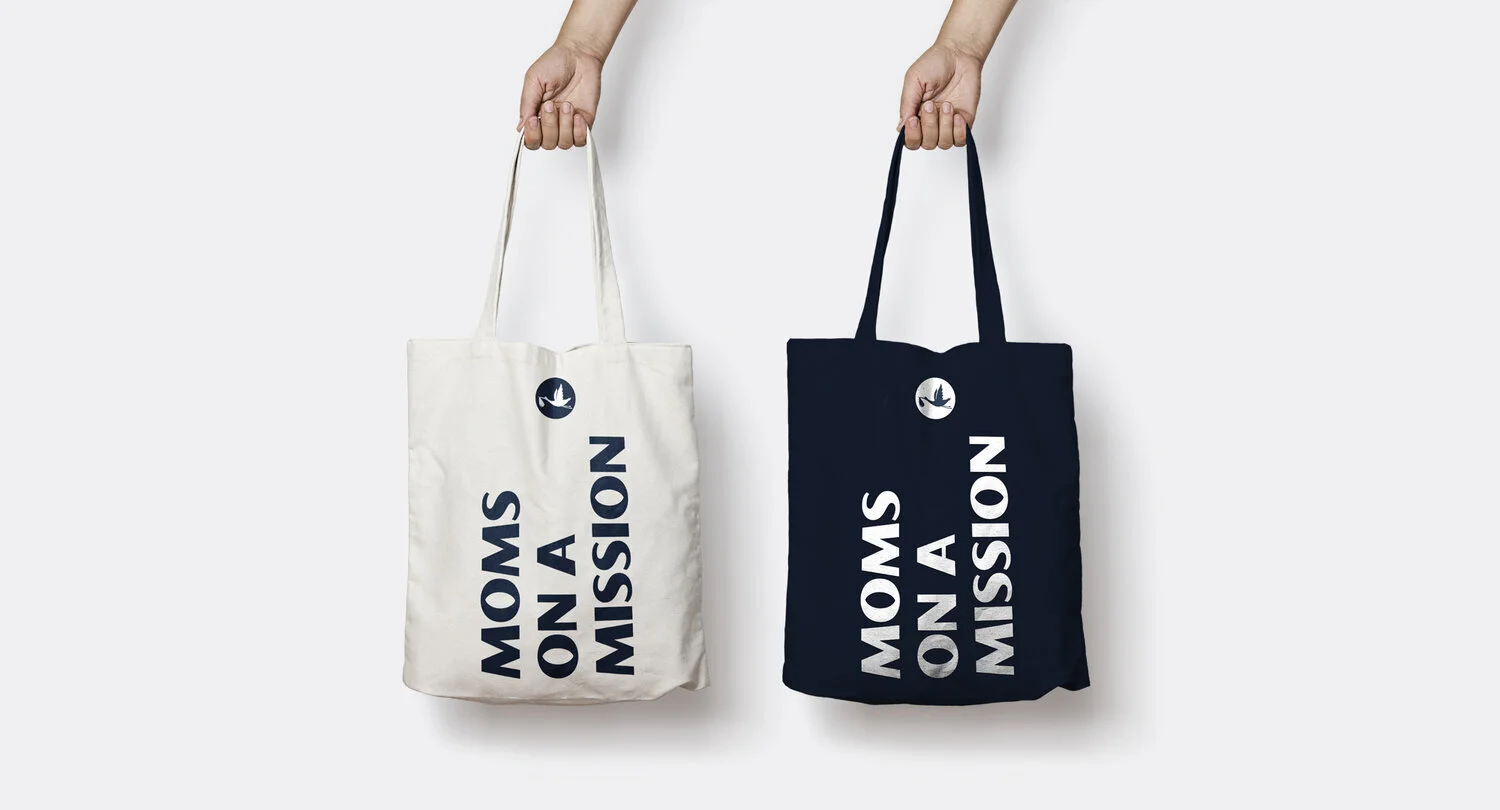 Milkstork tote bags that say "Moms on a misson" in white and blue