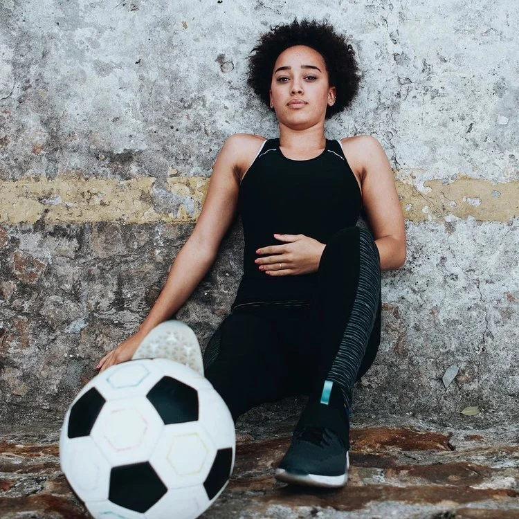 Woman against wall with soccer ball