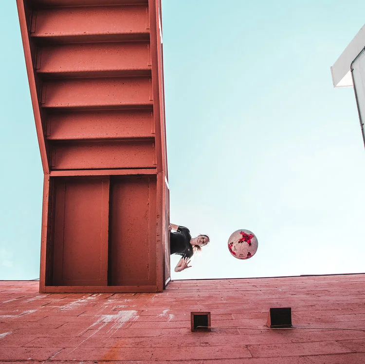 Woman on stairs with ball falling from above