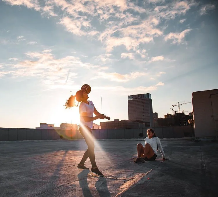 Two girls on top of a roof with a soccer ball