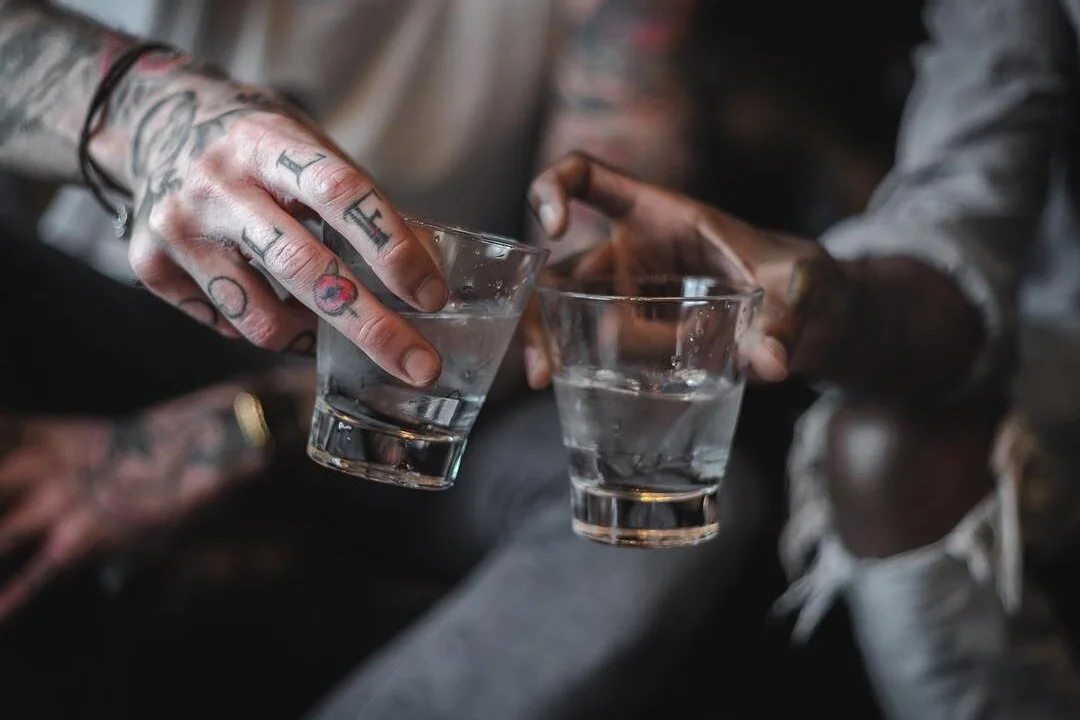 Two hands clinking glasses together