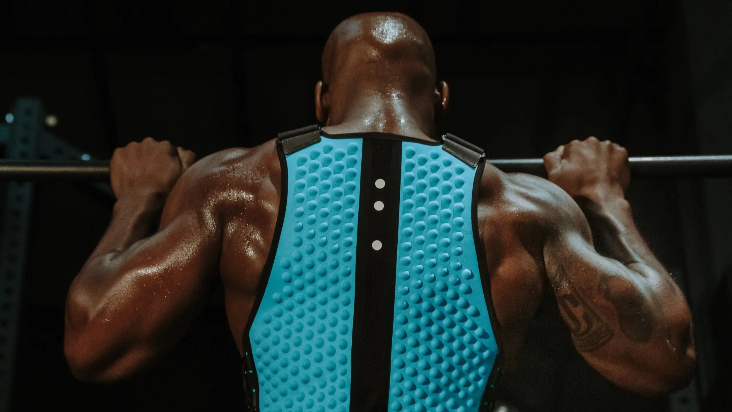 Back of Isaiah in Omorpho Weighted G-Vest doing a pull-up