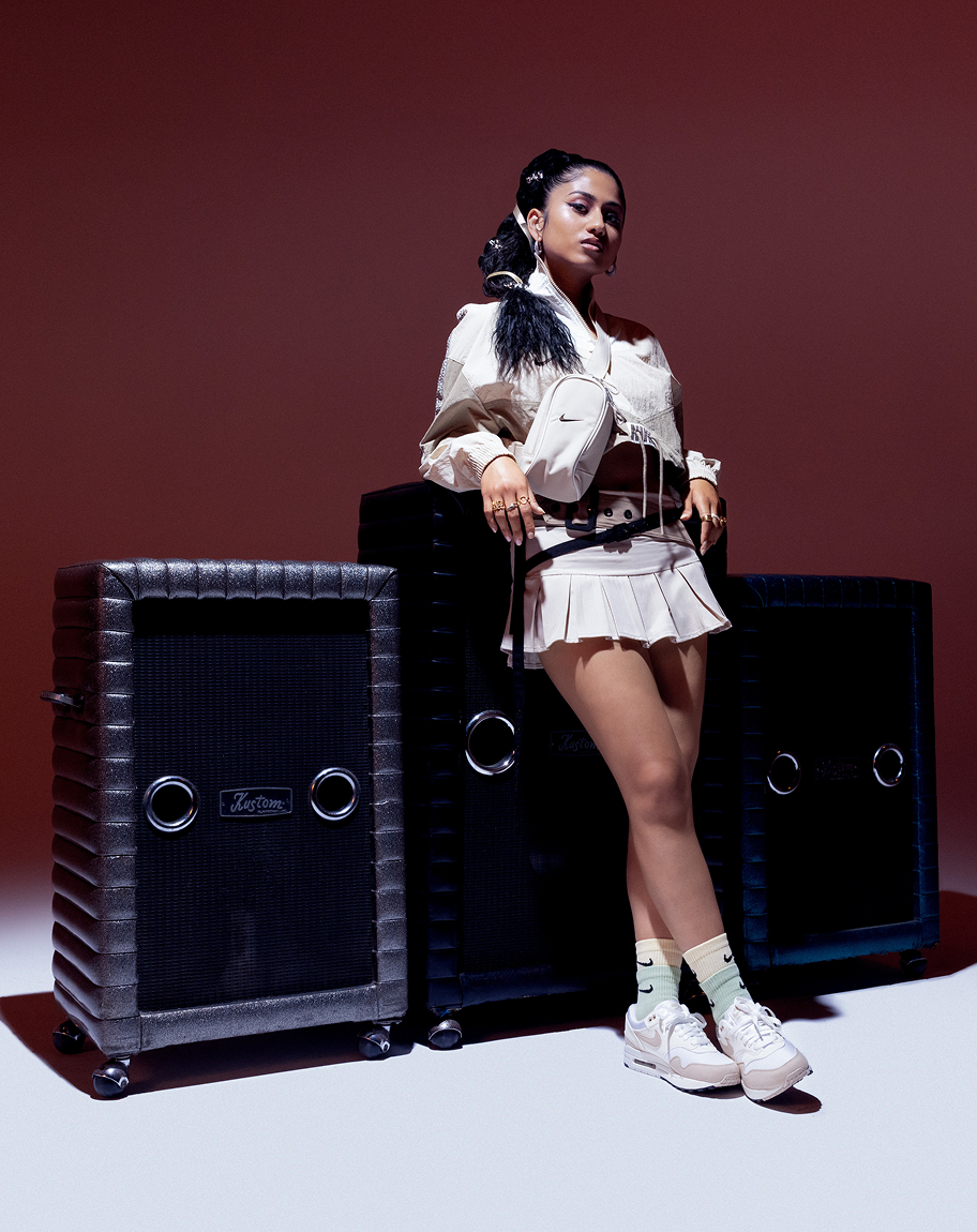 Ashley Mehta in front of speakers