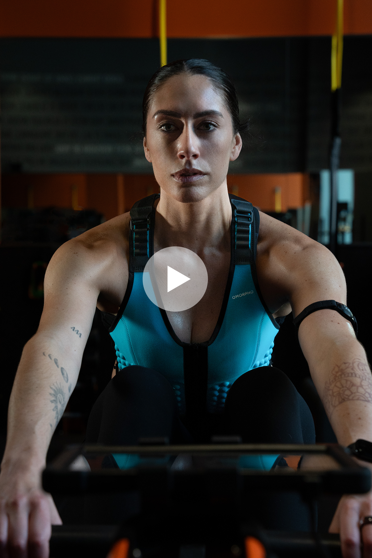 Close up in the gym of girl rowing in Omorpho Weighted G-Vest
