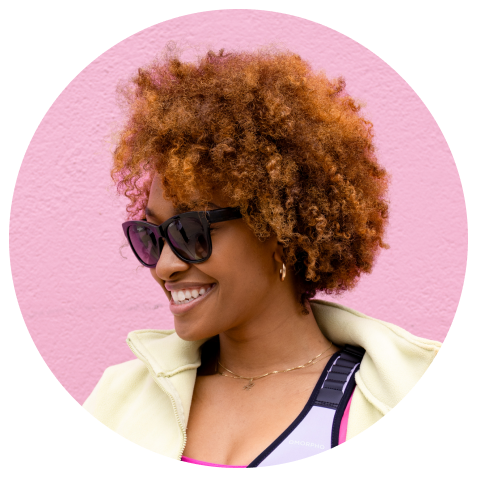 Close up of Amber Flowers wearing sunglasses infront of pink background