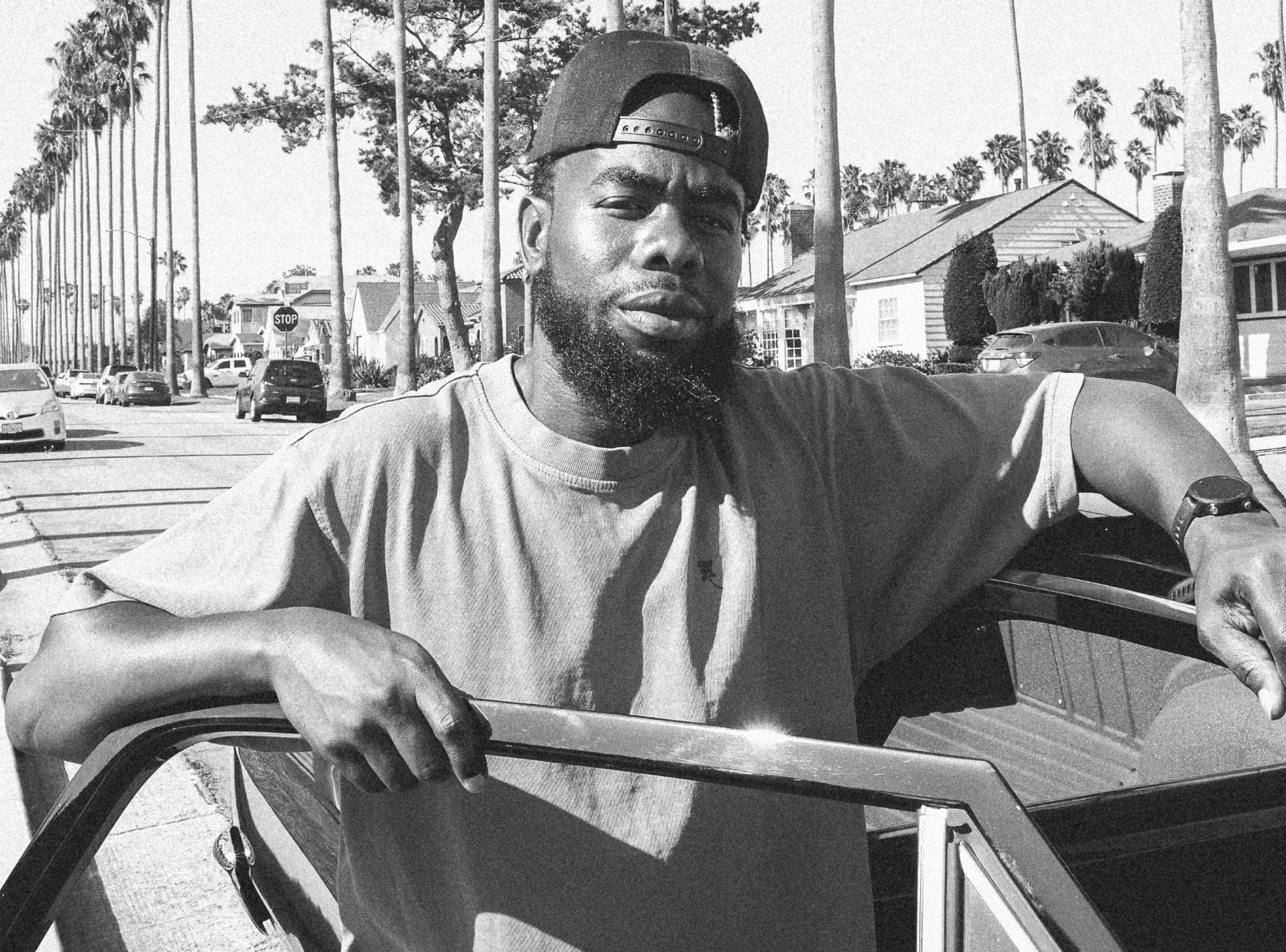 Black and white photo of man standing next to car in South Central merch