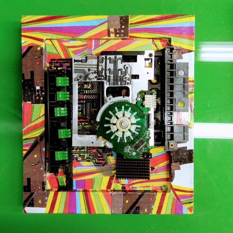 Internal view of a floppy disk drive with colorful geometric background.