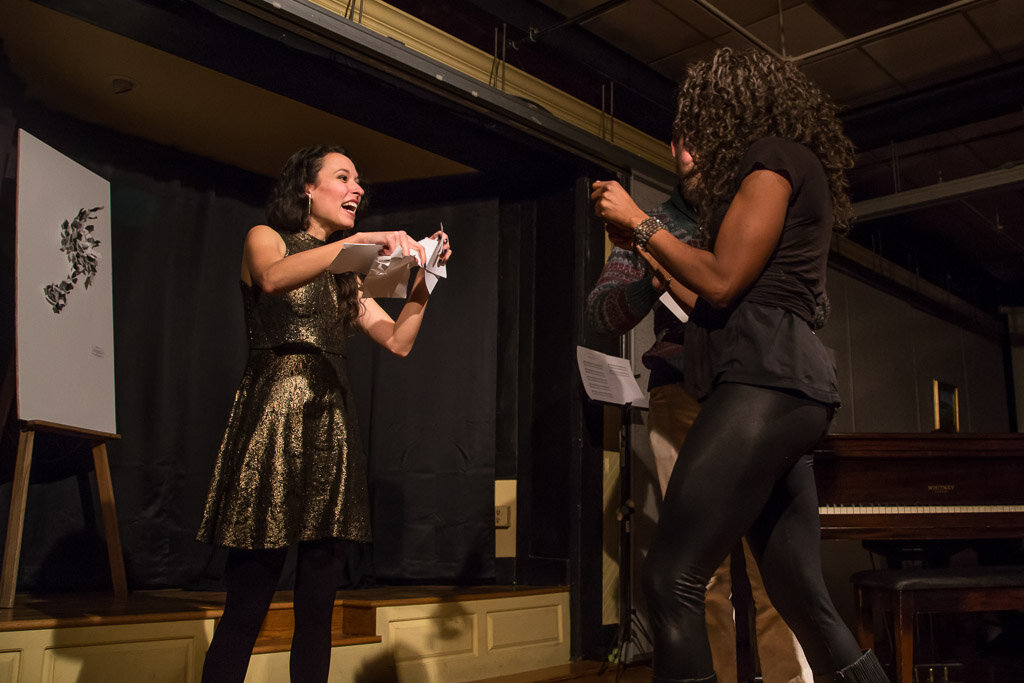 audience member bringing their paper to be released in tearing catharsis / photo by George Fargo
