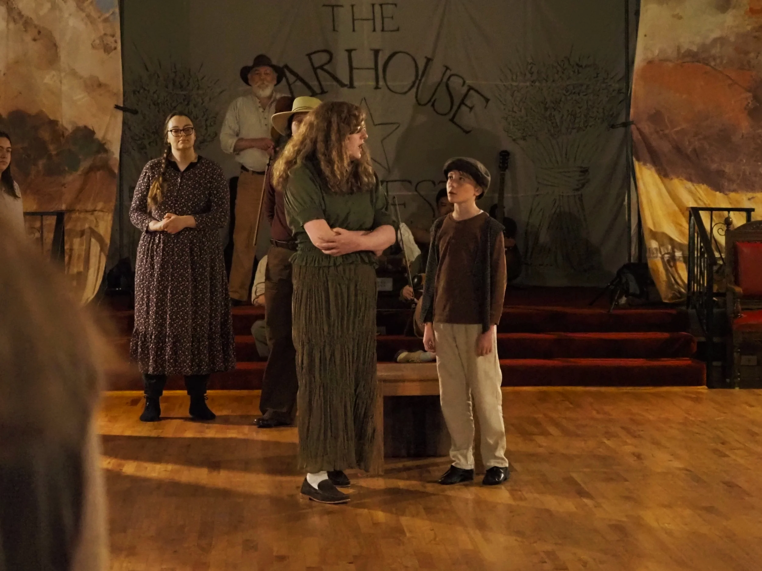 The Weaver begins telling the Child the story of Giselle, as the peasants look on