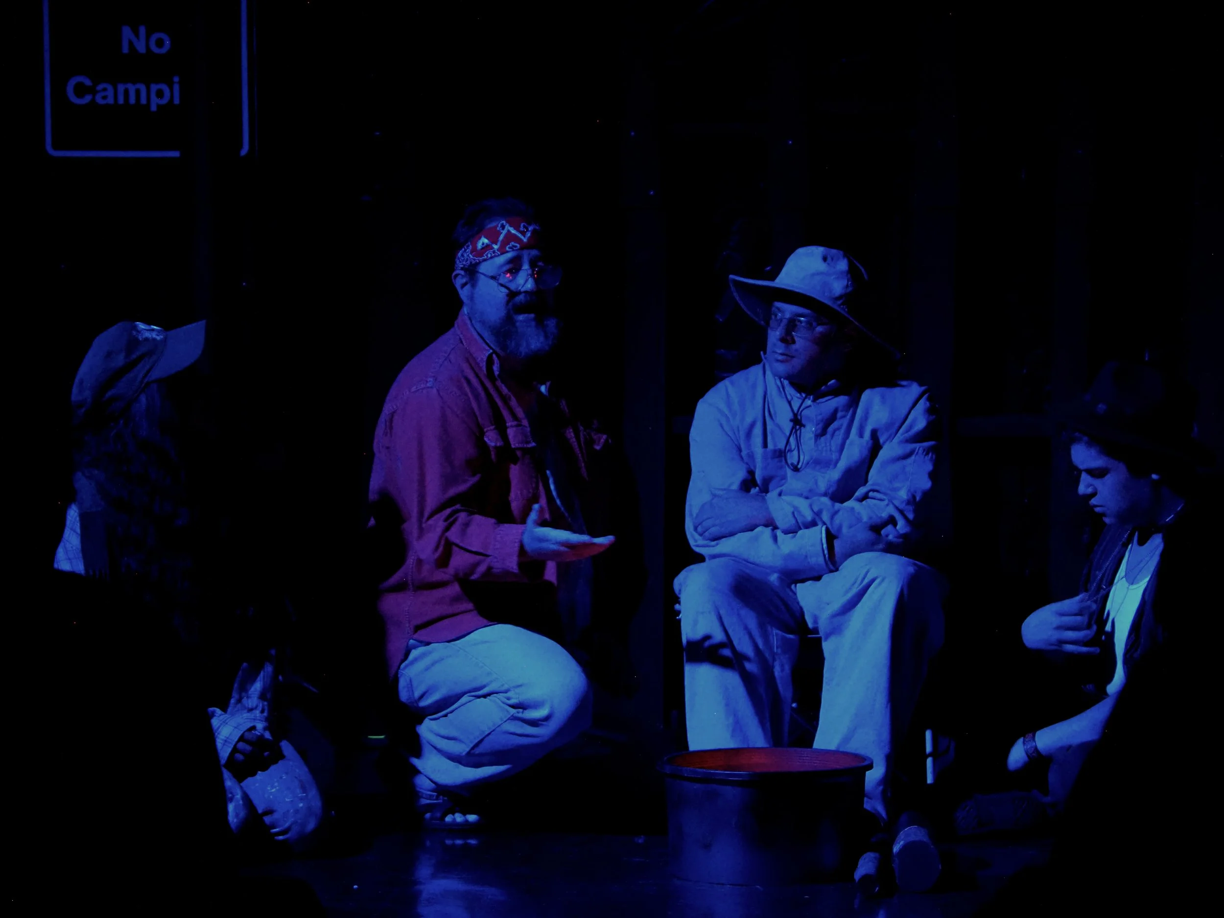 Duke Senior (Barry Smith) welcomes Adam (Kenny Silberburg) and Orlando (Caiden King) to his camp, as Silvius (Divya Pillai) looks on.