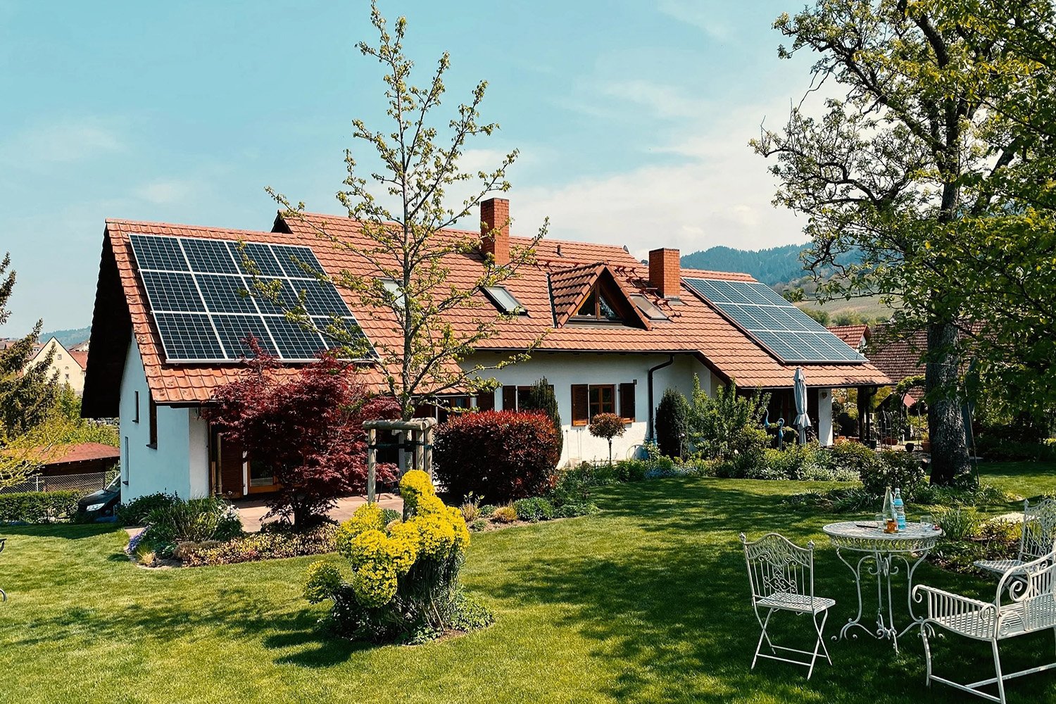 photovoltaikanlage auf einem schönen haus mit viel grün
