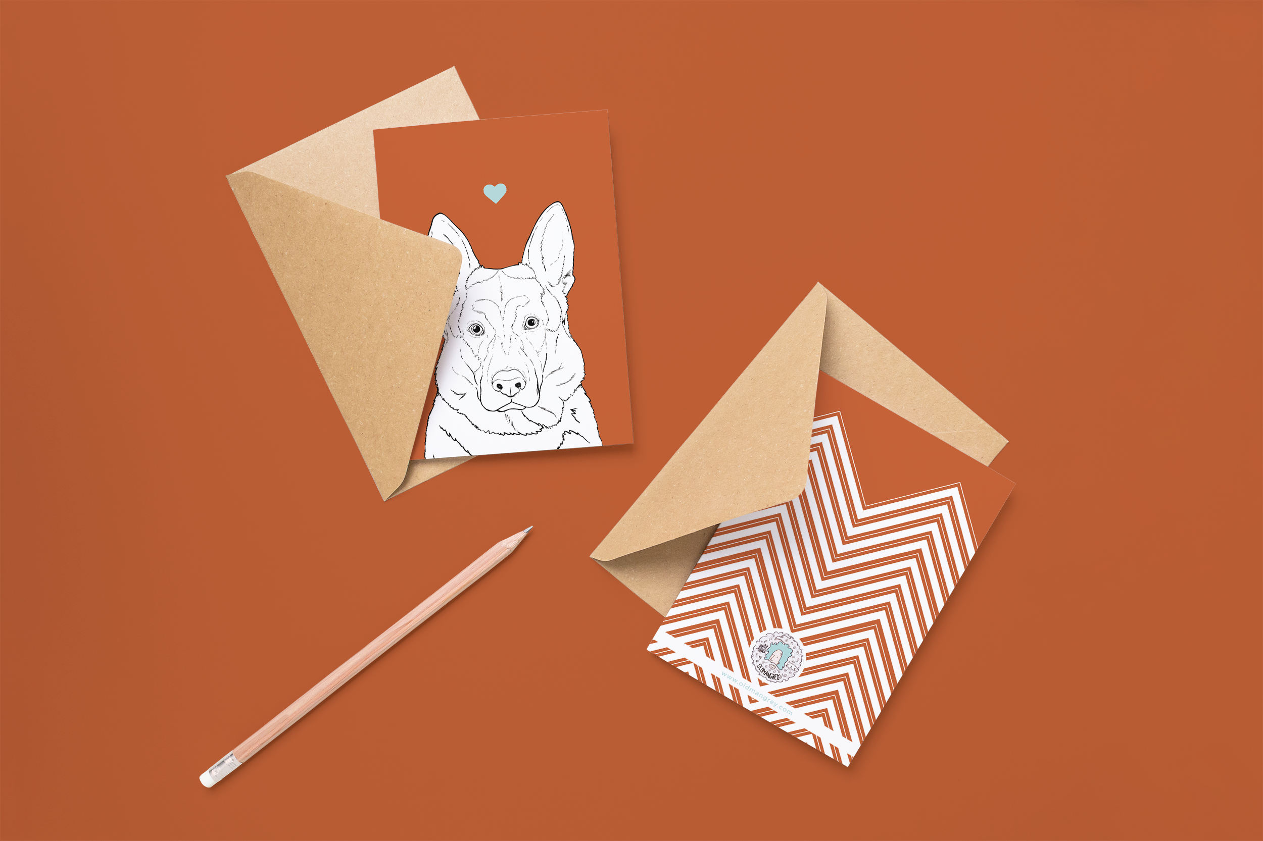 Two cards on brown envelopes, one face up one down. The card and image have a deep red coloured background, with a black & white digital illustration of the head & shoulders of an Alsatian dog.