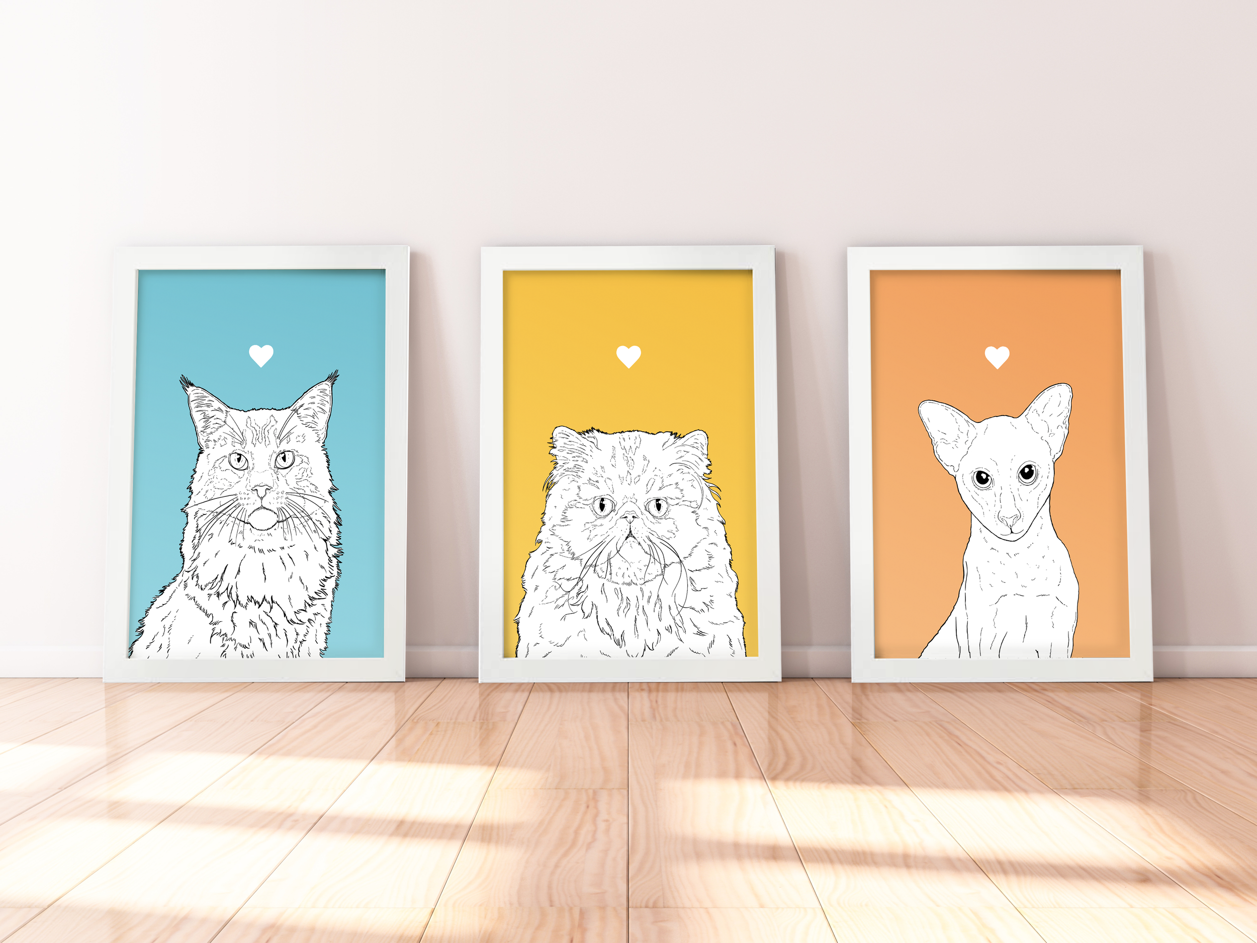 A trio of A4 prints in white wooden frames leaning against a white wall. Each has a black & white digital illustration of the head & shoulders of a different cat: Maine Coon, Persian & Oriental