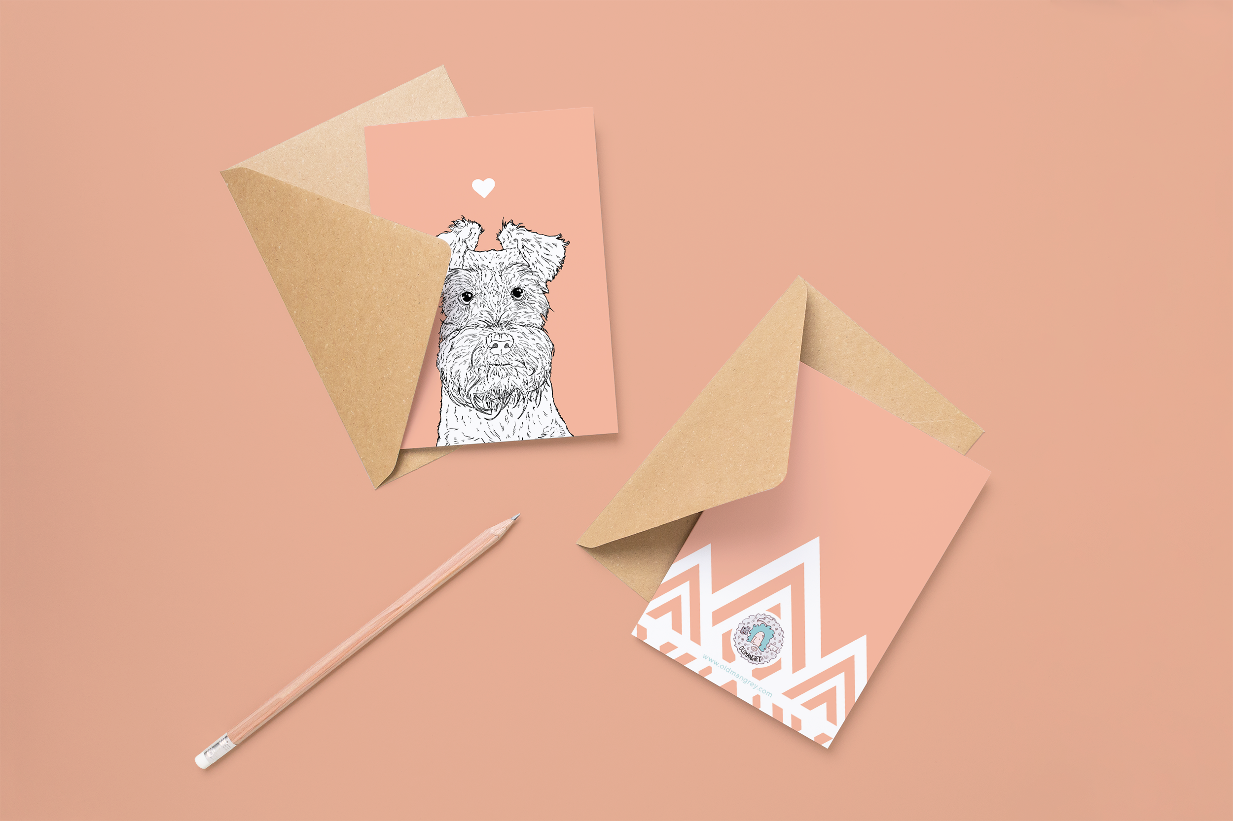 Two cards on brown envelopes, one face up one down. The card and image have a pale pink coloured background, with a black & white digital illustration of the head & shoulders of a Mini Schnauzer dog.