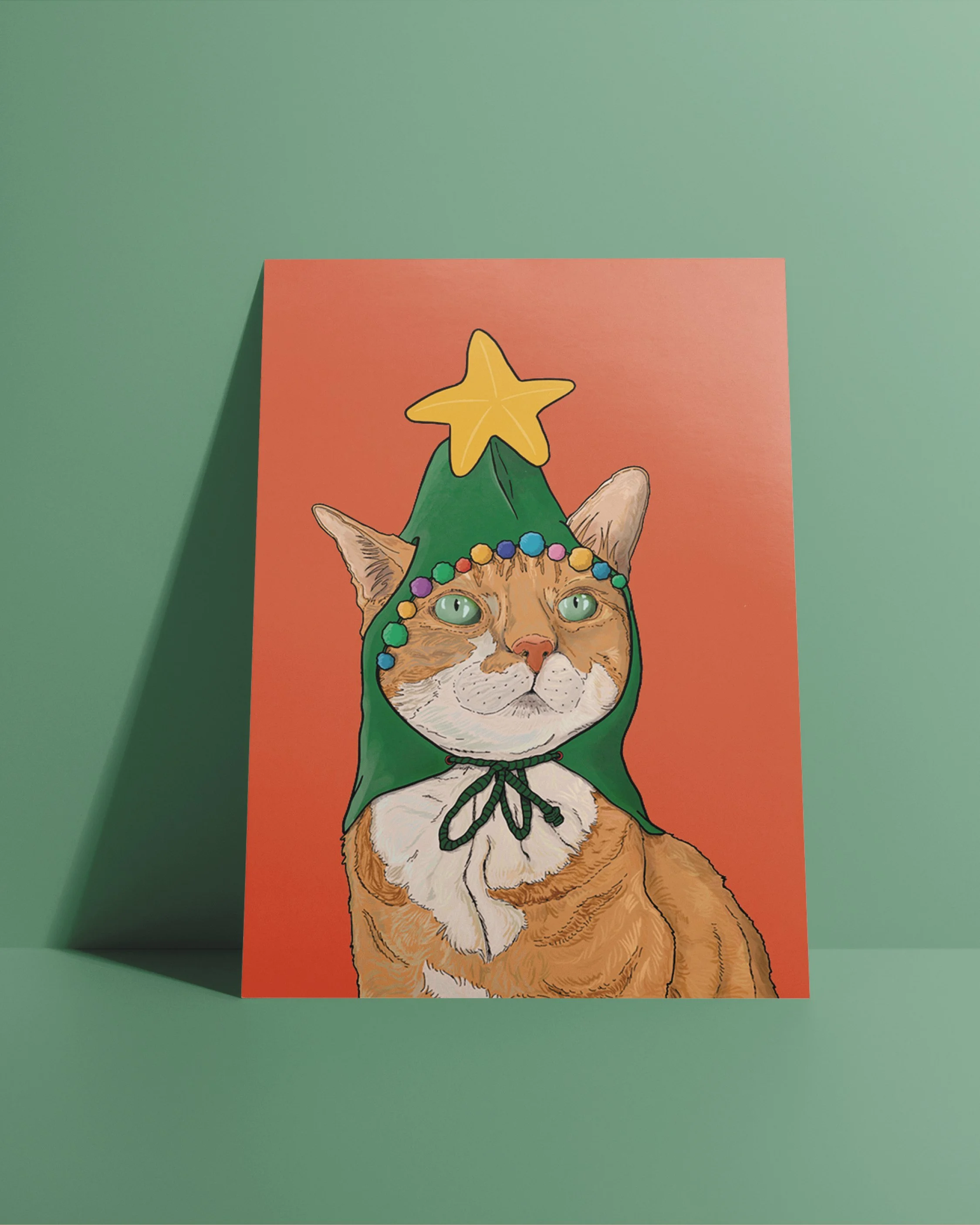 An A6 Cat Christmas Card, bright digital illustration of a ginger cat in a green Christmas tree hat! Set on a flat red background