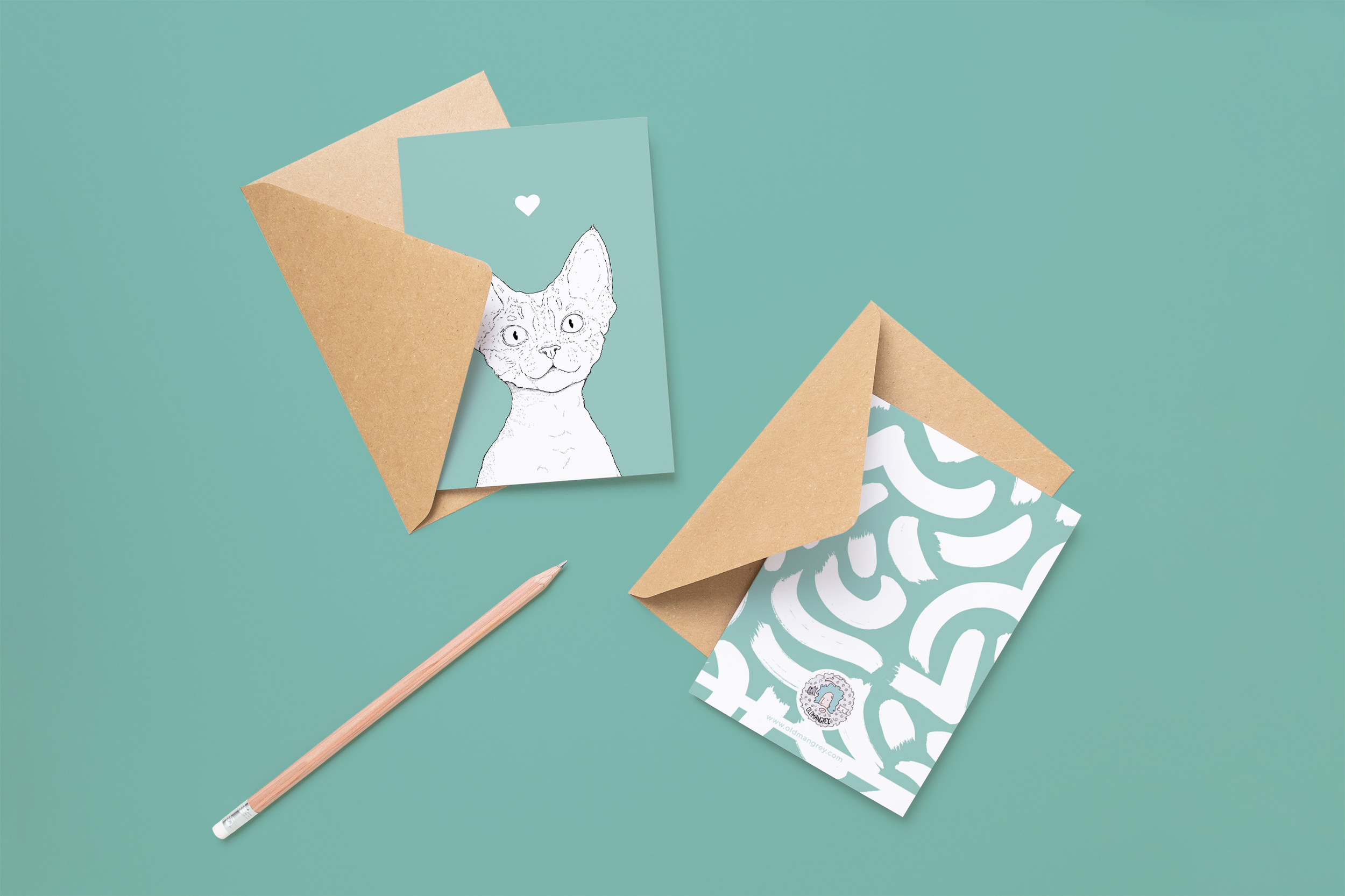 Two cards on brown envelopes, one face up one down. The card and image have a pale sage green coloured background, with a black & white digital illustration of the head & shoulders of a Devon Rex cat.