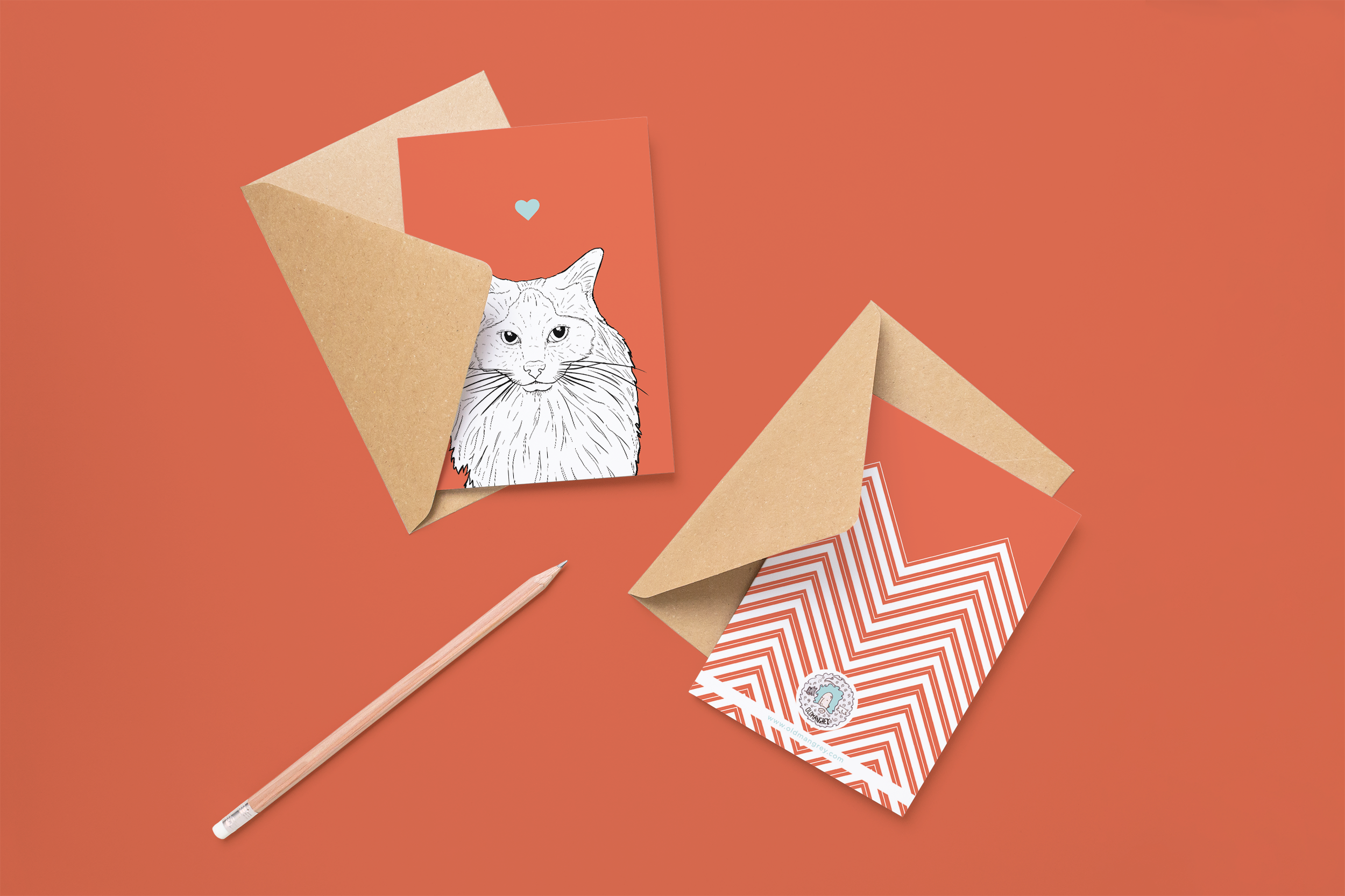 Two cards on brown envelopes, one face up one down. The card and image have a red coloured background, with a black & white digital illustration of the head & shoulders of a Ragdoll cat.