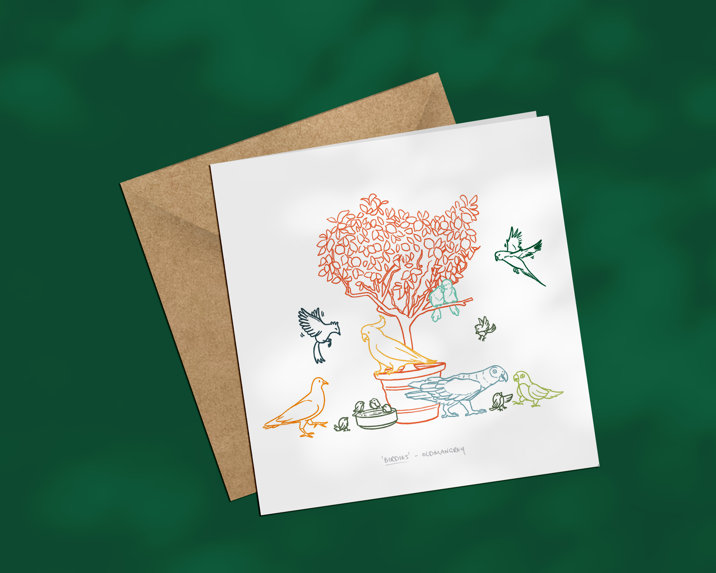 A square greetings card on a brown envelope, with a colourful digital illustration of birds on & around a small tree. The image has a deep green background.