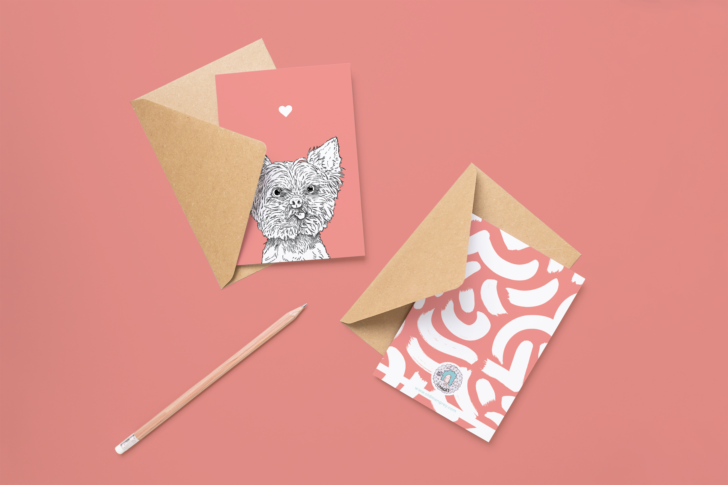Two cards on brown envelopes, one face up one down. The card and image have a pale pink coloured background, with a black & white digital illustration of the head & shoulders of a Yorkie dog.