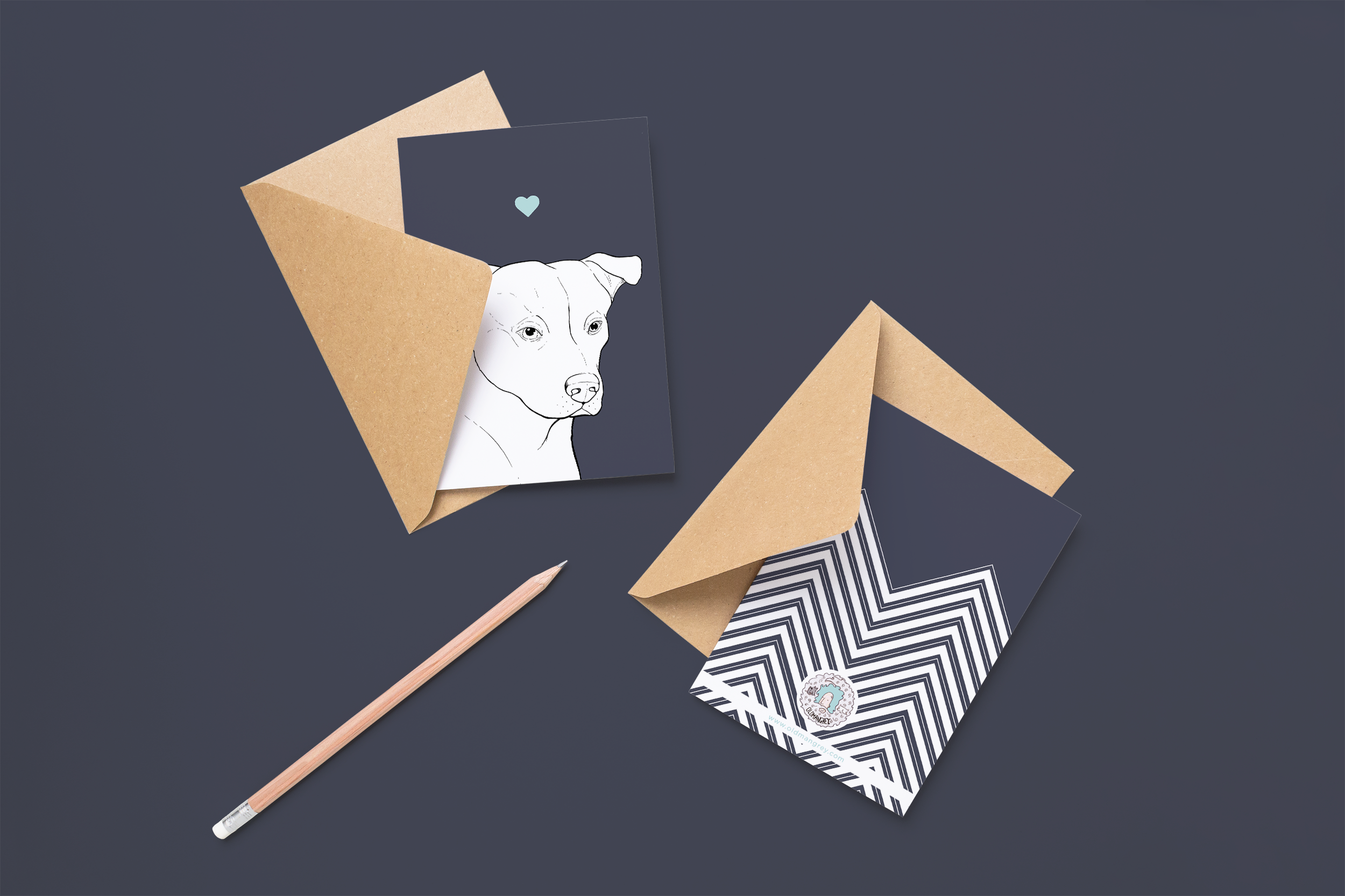 Two cards on brown envelopes, one face up one down. The card and image have a navy blue coloured background, with a black & white digital illustration of the head & shoulders of a Staffie dog.