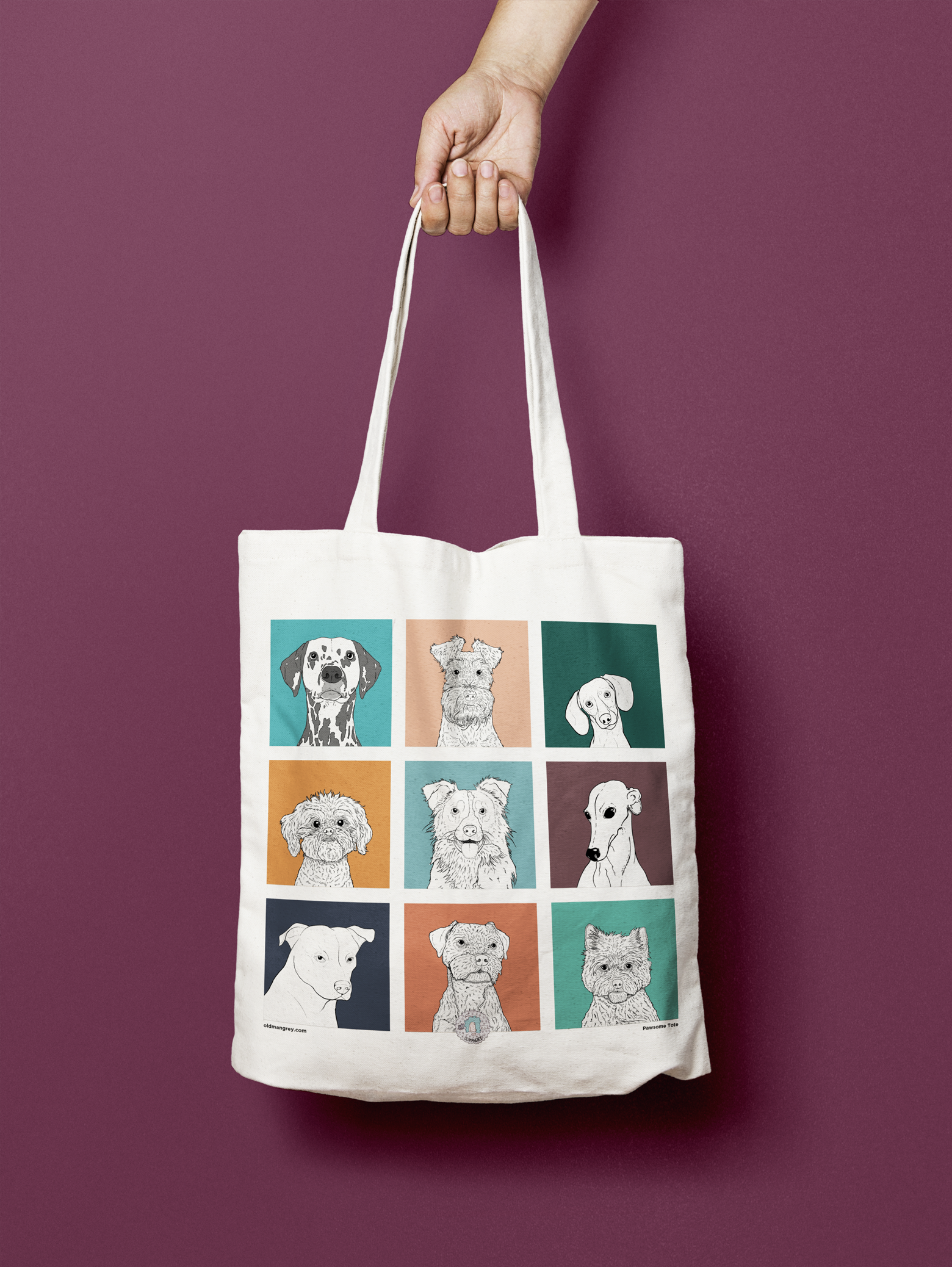 A tote bag hanging in front of a purple backdrop. It has a 3 by 3 grid of brightly coloured boxes, each with a black & white digital illustration of the head & shoulders of a different dog breed.