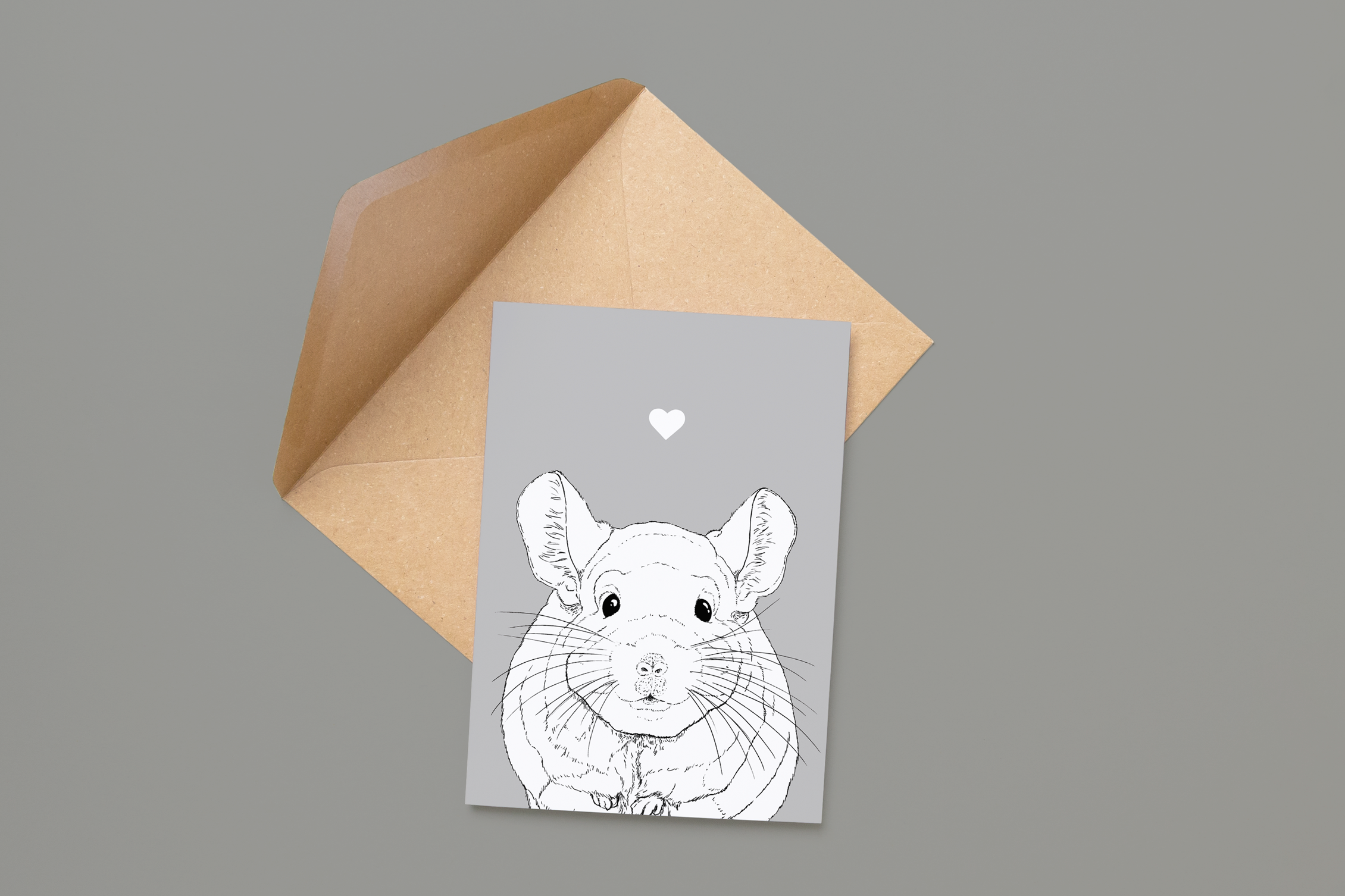 An A6 greetings card on a brown envelope. The card & image have a grey background, with a black & white digital illustration of the head & shoulders of a Chinchilla.