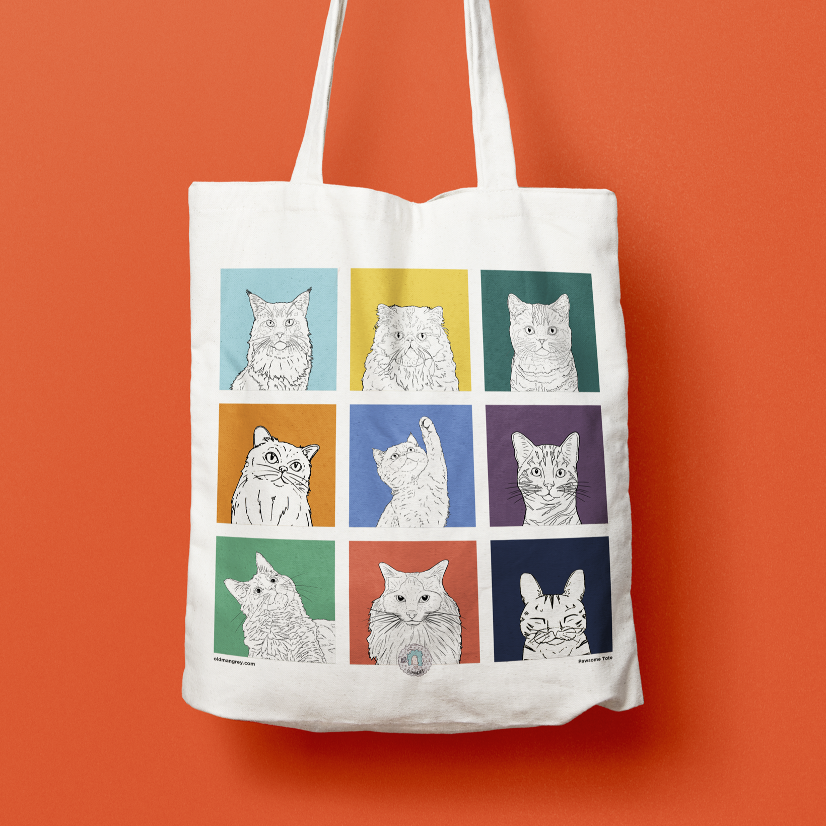 A close up of a tote bag in front of a red backdrop, with a 3 by 3 grid of brightly coloured boxes, each with a black & white digital illustration of the head & shoulders of a different cat breed.
