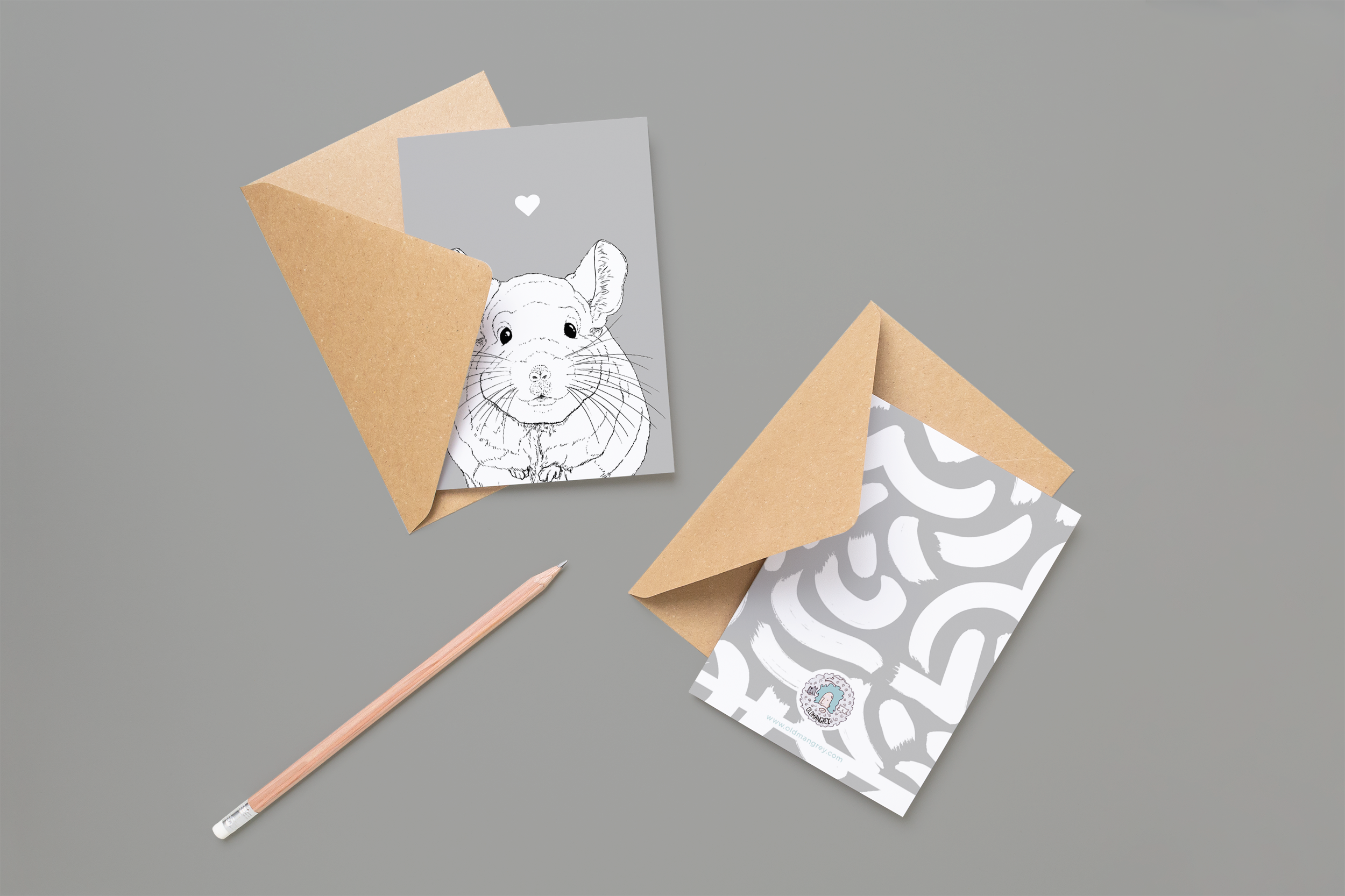 Two cards on brown envelopes, one face up one down. The card and image have a grey coloured background, with a black & white digital illustration of the head & shoulders of a Chinchilla.