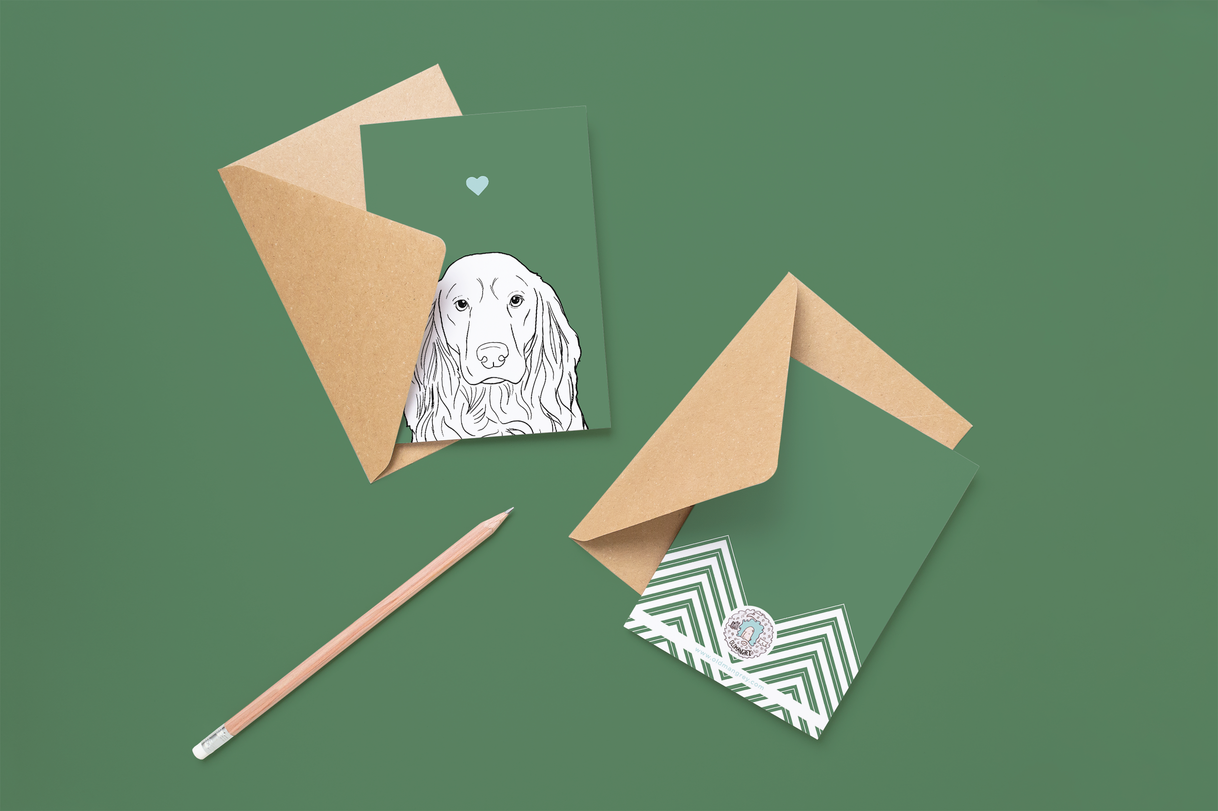 Two cards on brown envelopes, one face up one down. The card and image have a green coloured background, with a black & white digital illustration of the head & shoulders of a Cocker Spaniel dog.