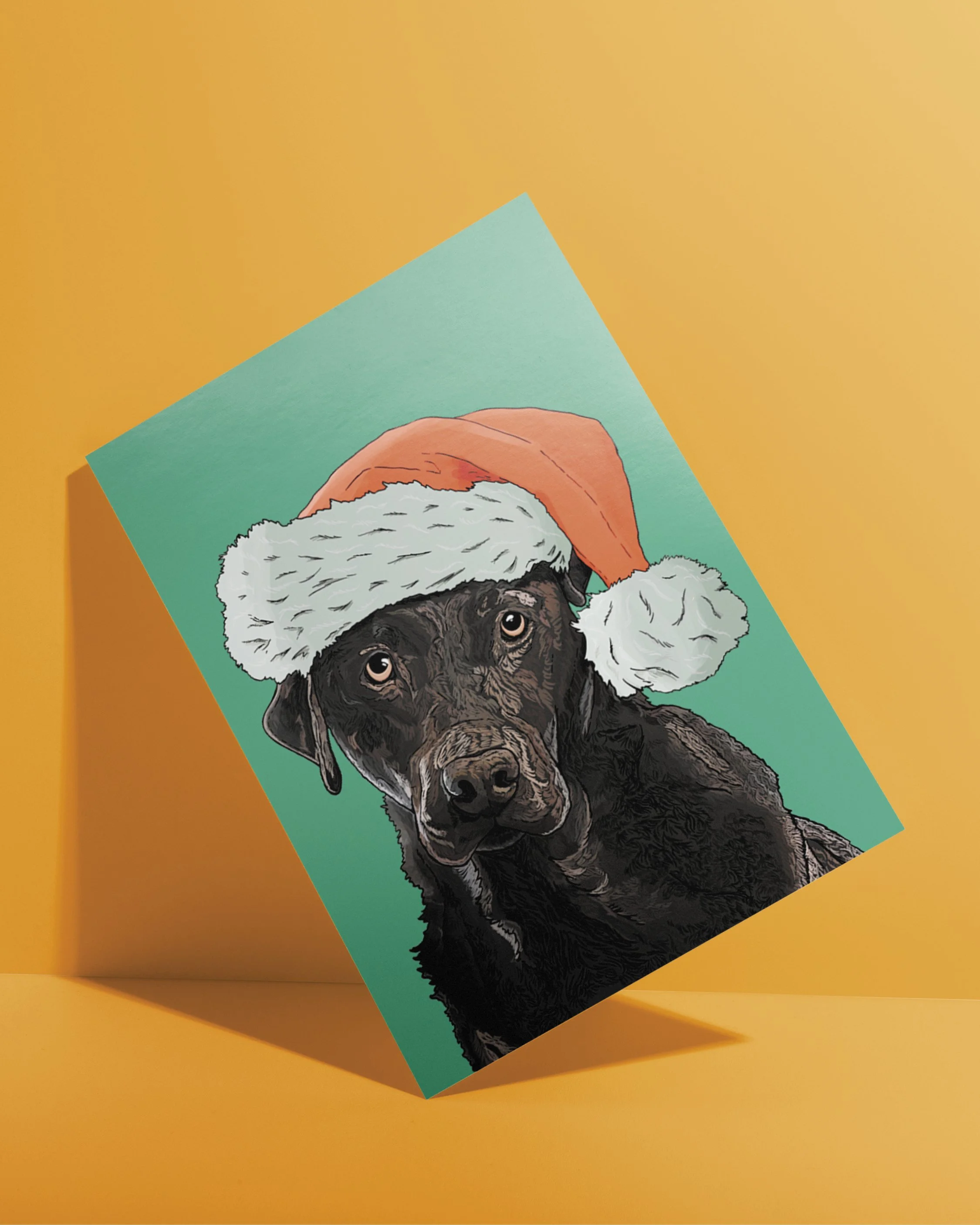 A6 Dog Christmas Card, bright digital illustration of a black Labrador dog in a red Santa hat! Set on a flat turquoise background.