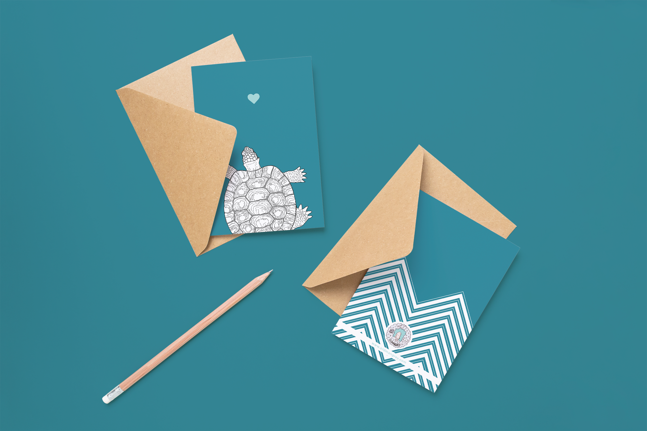 Two cards on brown envelopes, one face up one down. The card and image have a deep teal coloured background, with a black & white digital illustration of a Tortoise.