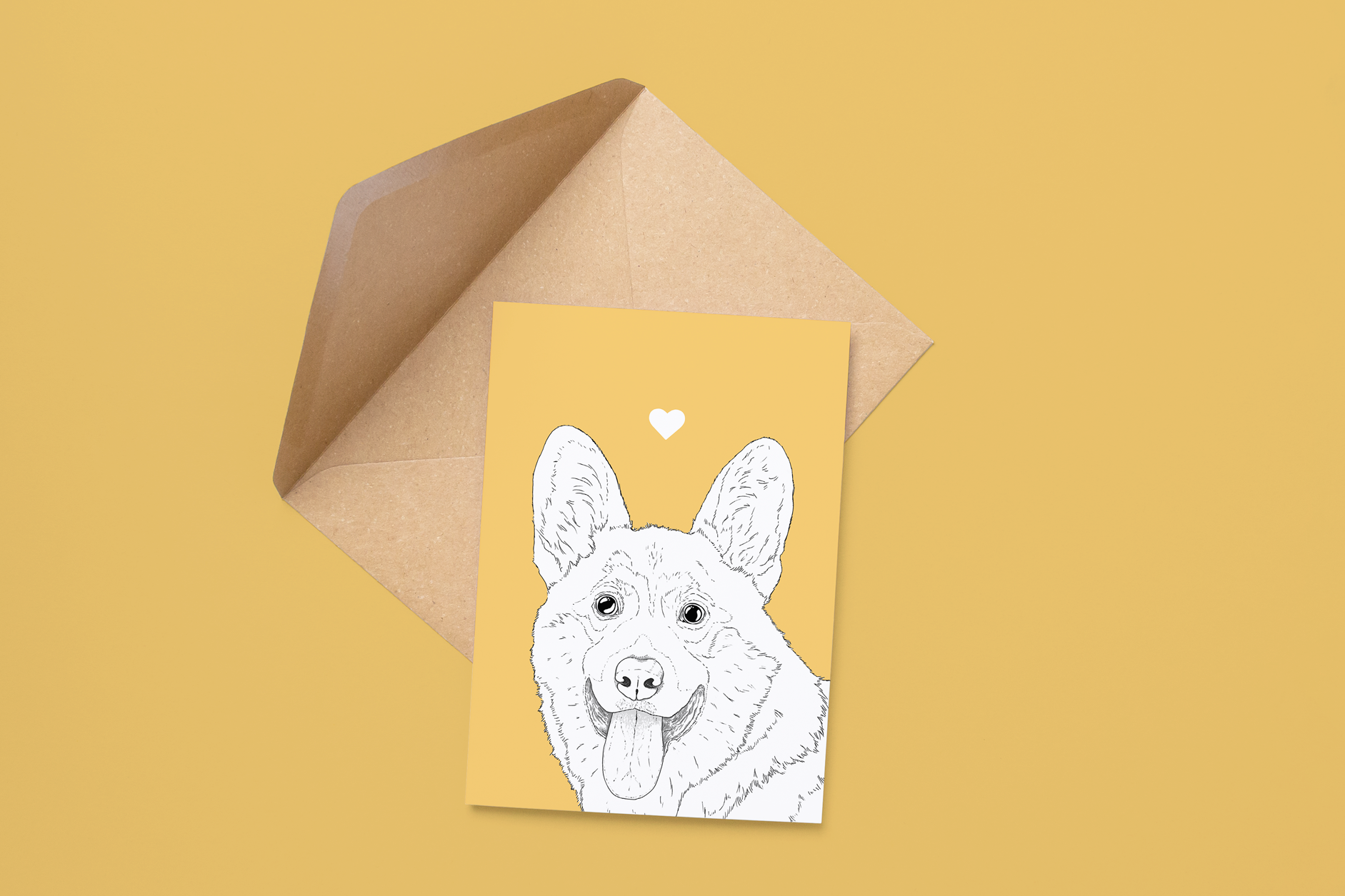 An A6 greetings card on a brown envelope. The card & image have a warm yellow background, with a black & white digital illustration of the head & shoulders of a Corgi dog.