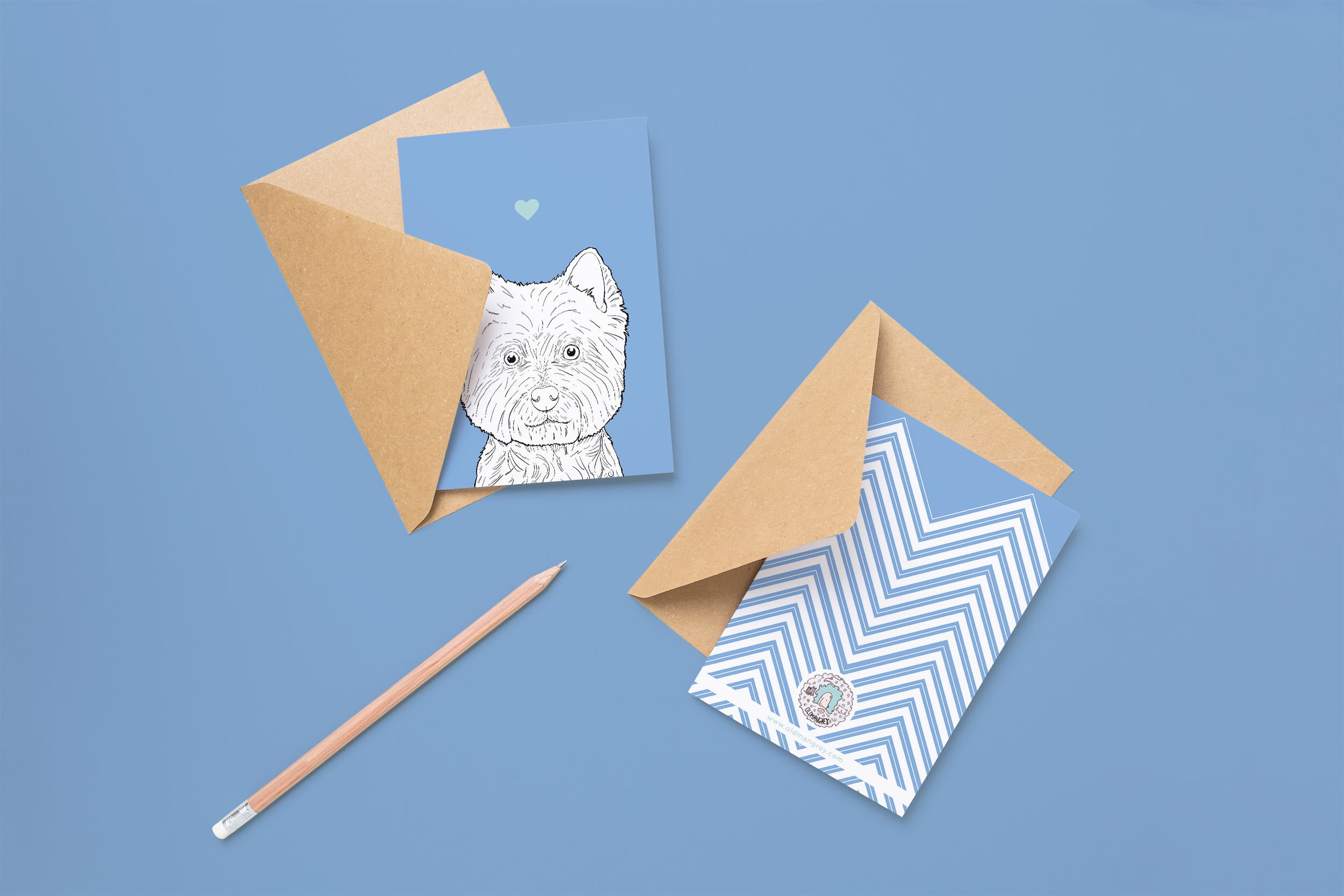 Two cards on brown envelopes, one face up one down. The card and image have a pale blue coloured background, with a black & white digital illustration of the head & shoulders of a Westie dog.