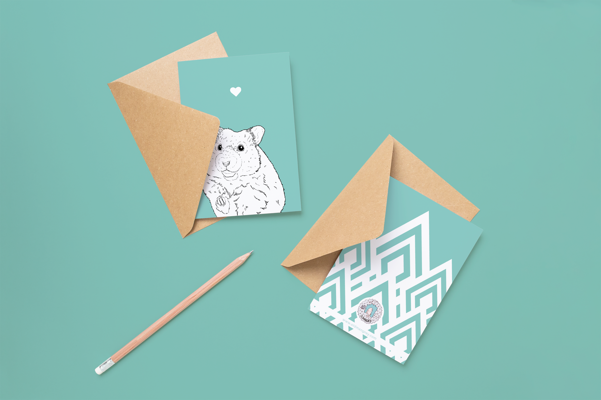 Two cards on brown envelopes, one face up one down. The card and image have a pale blue coloured background, with a black & white digital illustration of the head & shoulders of a Hamster.