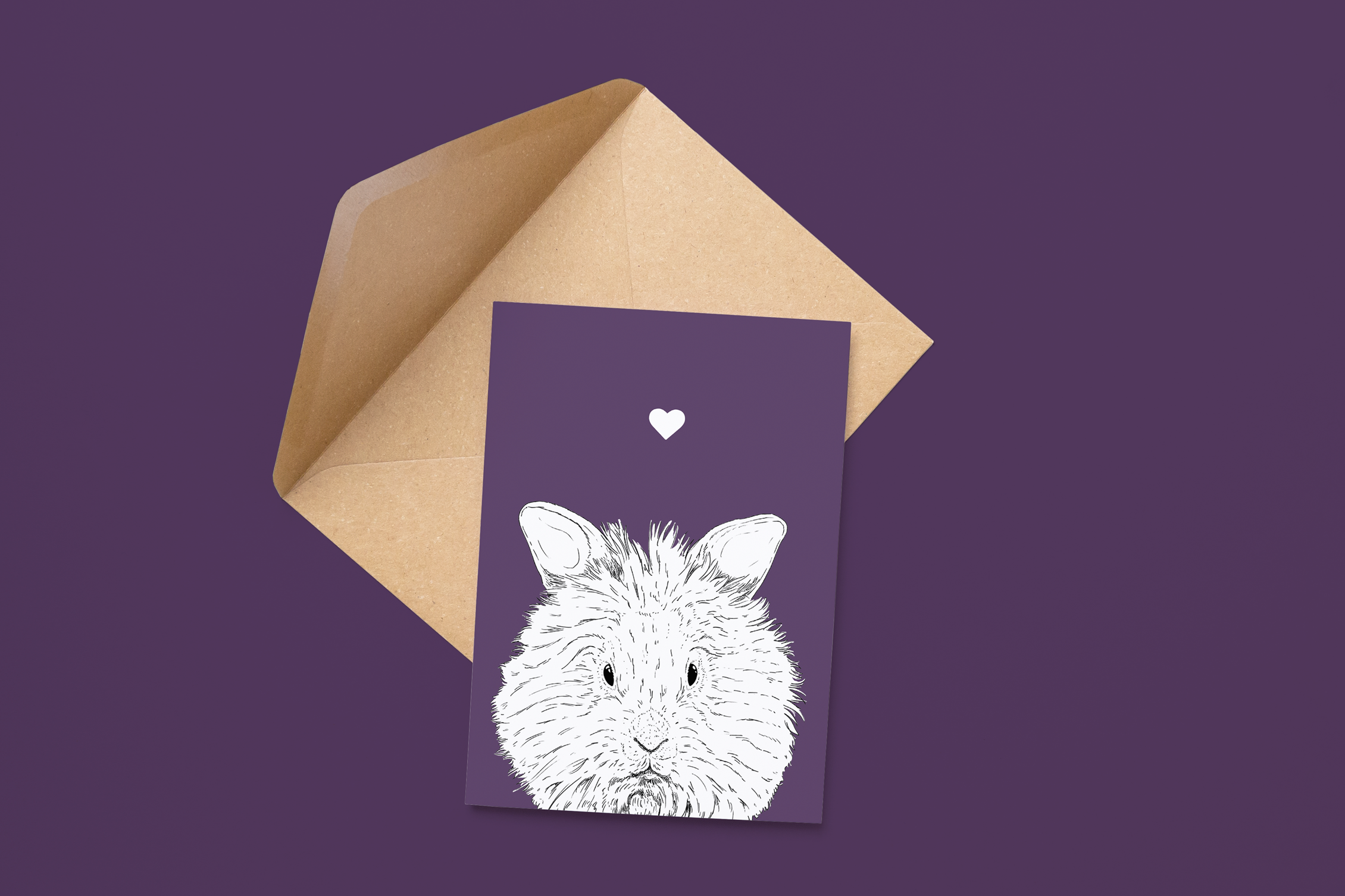An A6 greetings card on a brown envelope. The card & image have a deep purple background, with a black & white digital illustration of the head & shoulders of a furry Lionhead Rabbit.