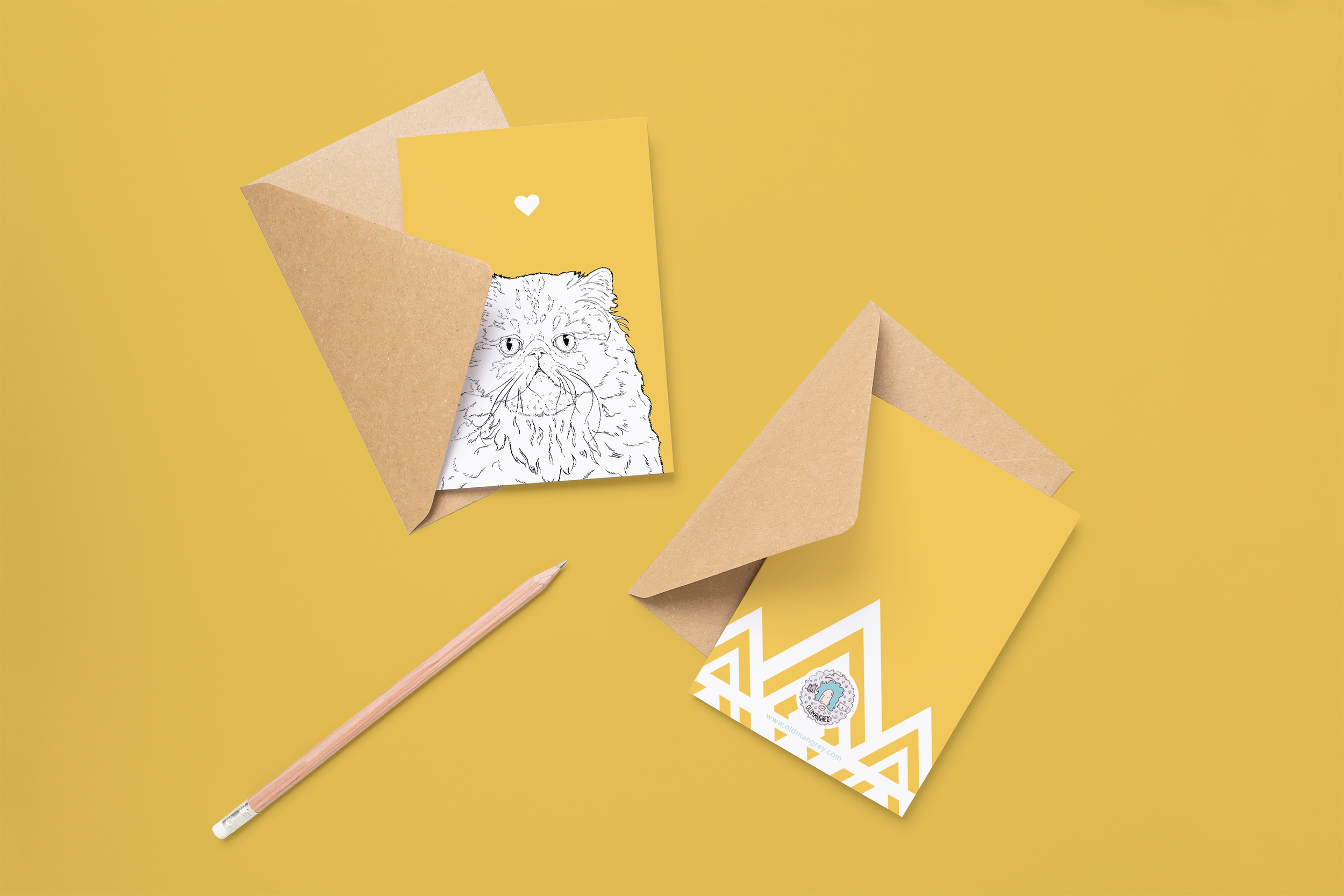 Two cards on brown envelopes, one face up one down. The card and image have a yellow orange coloured background, with a black & white digital illustration of the head & shoulders of a Persian cat.