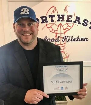Scott Kammerer, SoDel Concepts president, holds the Restaurant Neighbor Award honoring outstanding community service and involvement.