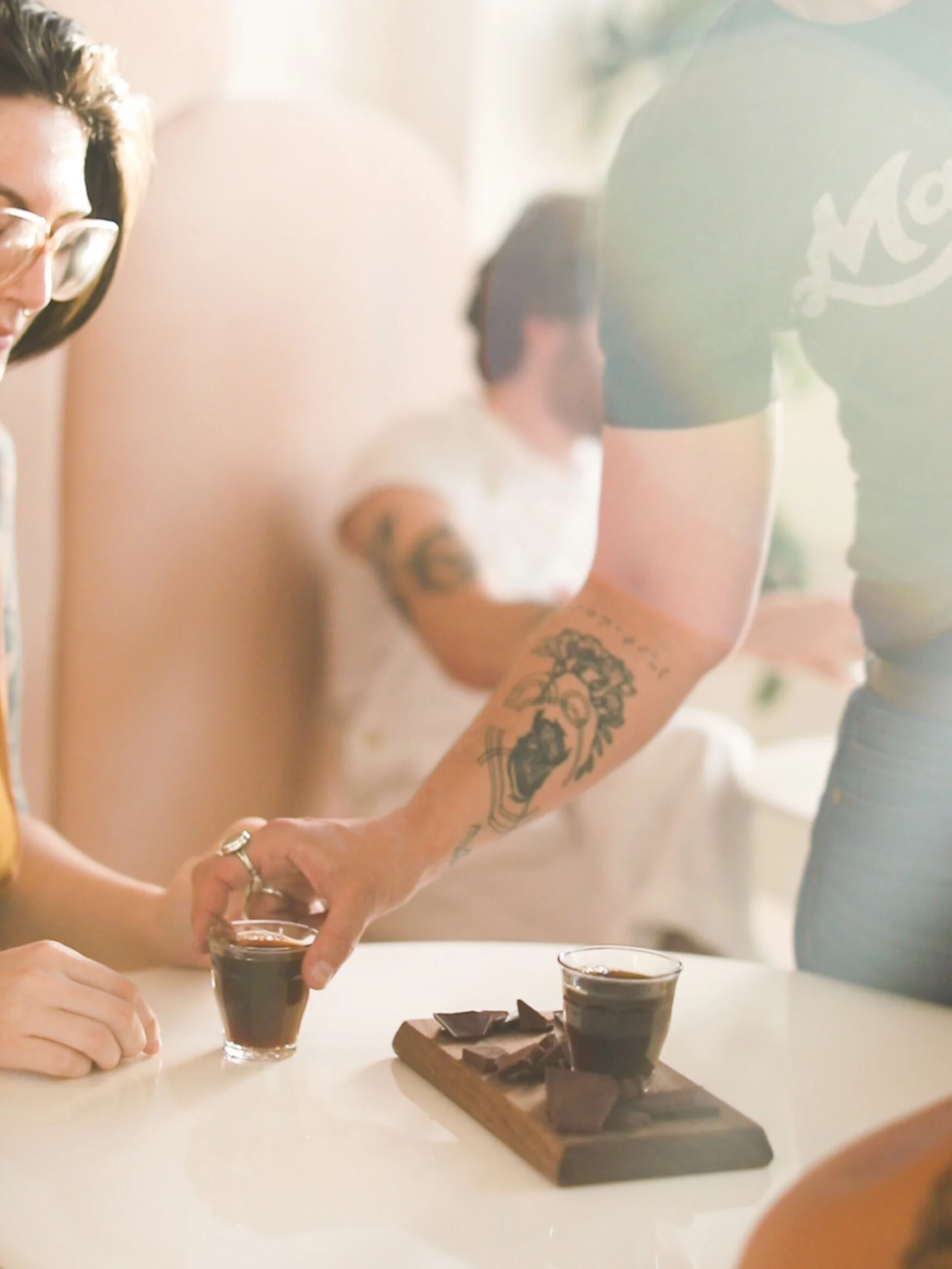 barista serving coffee and chocolate pairing board to female customer