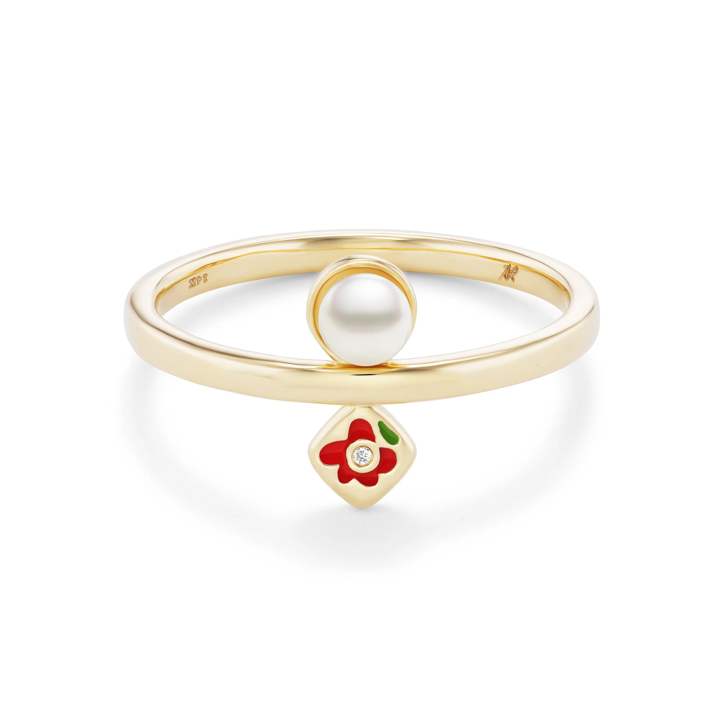 Close-up of a pearl ring with a gold band and a small red and green floral motif charm hanging from it, photographed on a white background.