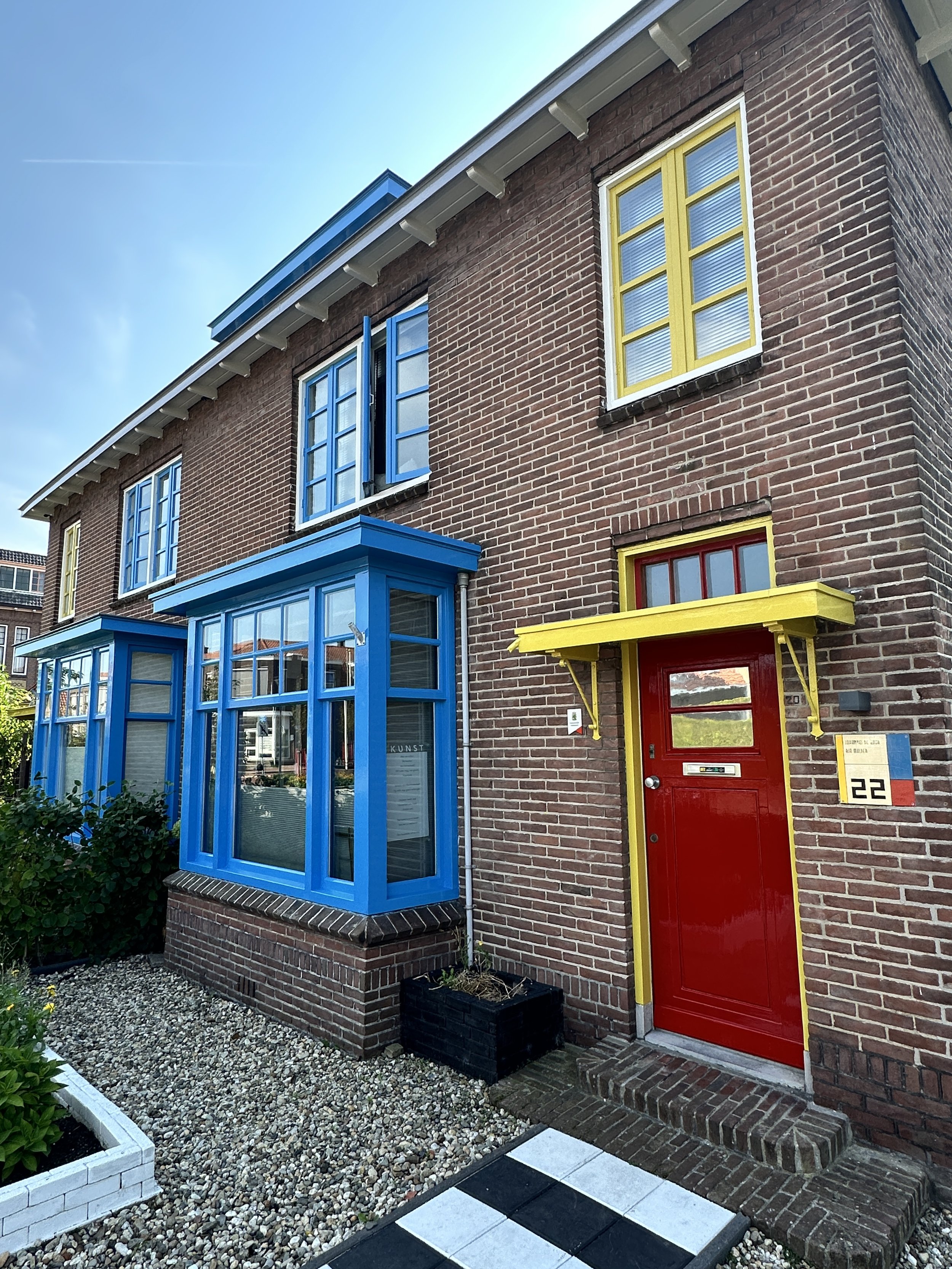 Buitenschilderwerk van woning in de Papegaaienbuurt Drachten – kleurrijke gevel met rode deur en blauwe kozijnen geschilderd door Schilderwerken Drachten