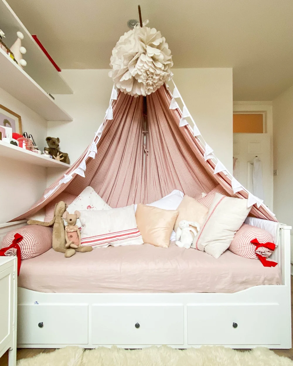 The baby’s room features a dramatic canopy bed