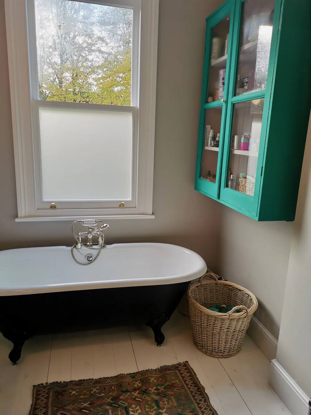 The en-suite bathroom features a cast-iron tub and a cabinet from Vintage Living painted in Annie Sloan chalk paint
