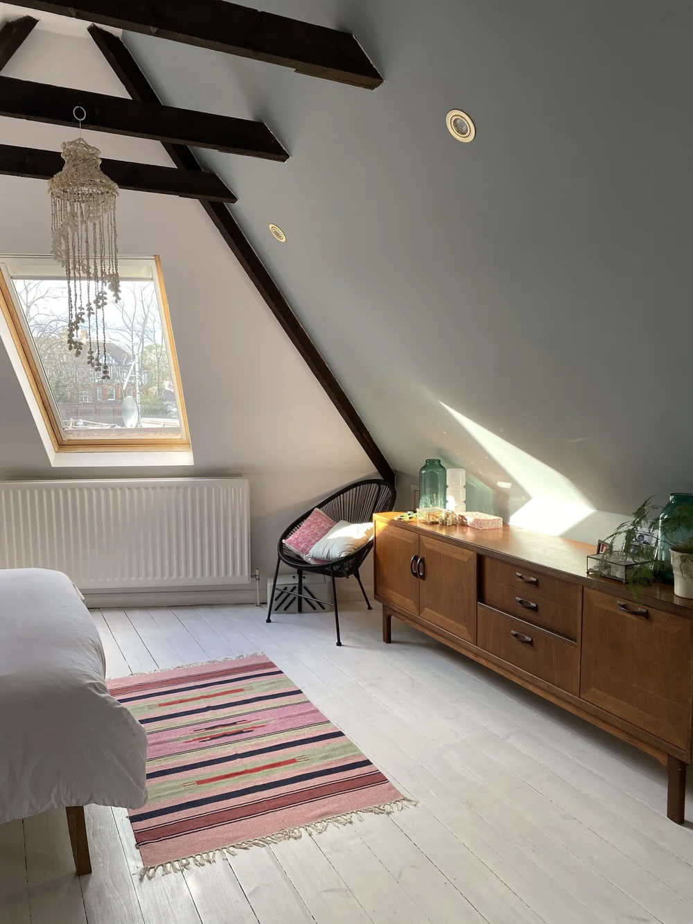 The bedroom wall is painted in Little Green Celestial Blue. The rug she found in a rural workshop in Rajasthan