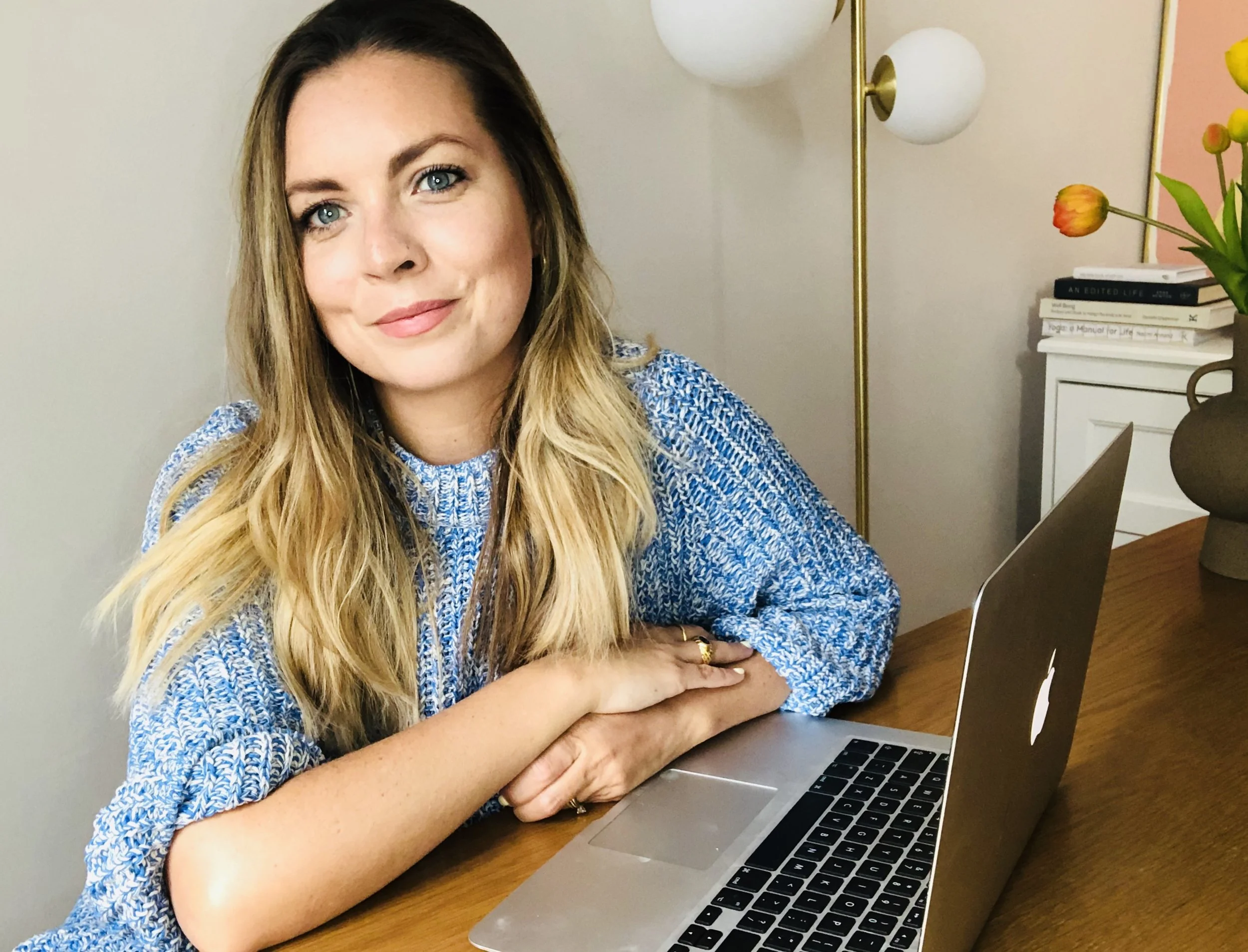 Abby Rawlinson, business coach for therapists and counsellors, smiling at her desk