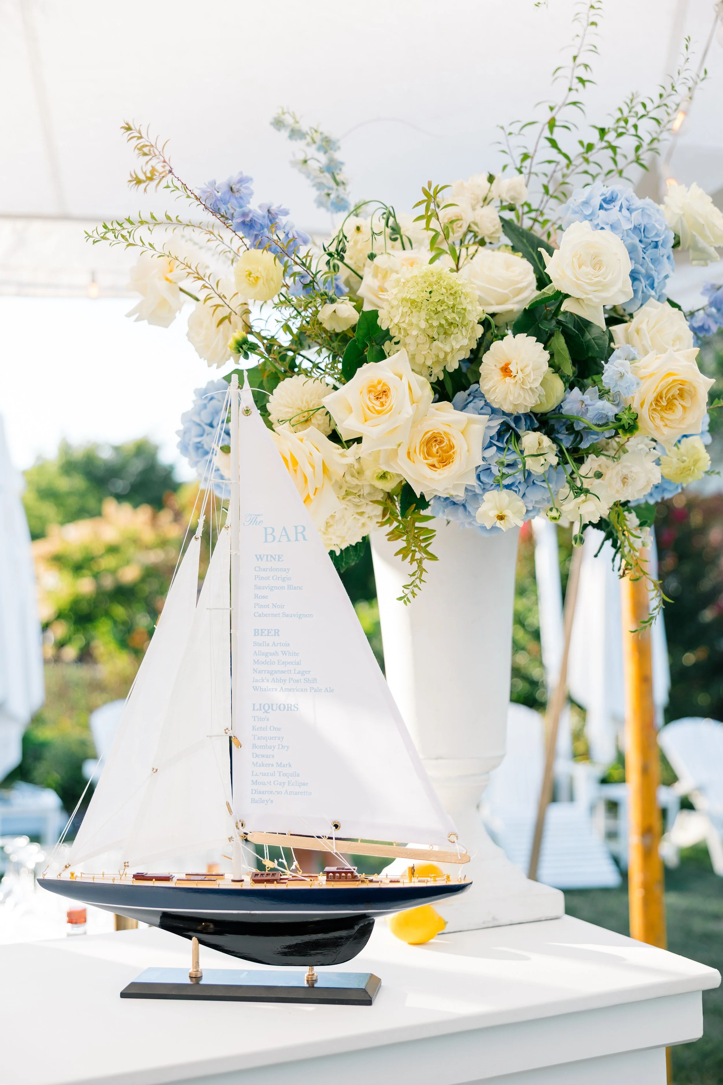 bar menu printed on mini sailboat for formal wedding rehearsal dinner decor