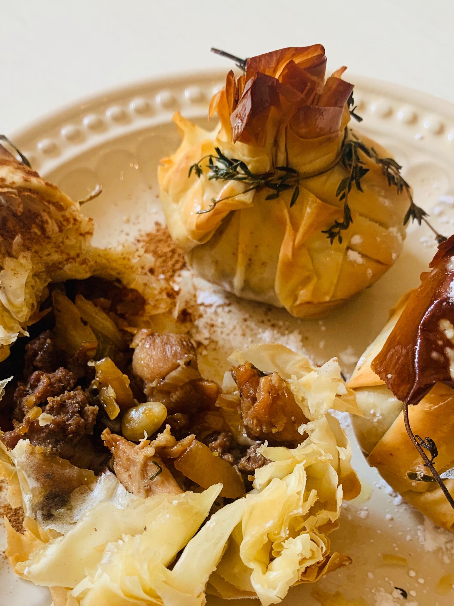 Moroccan “Pastilla” - meat stuffed phyllo sacks stuffed dried fruits and date honey